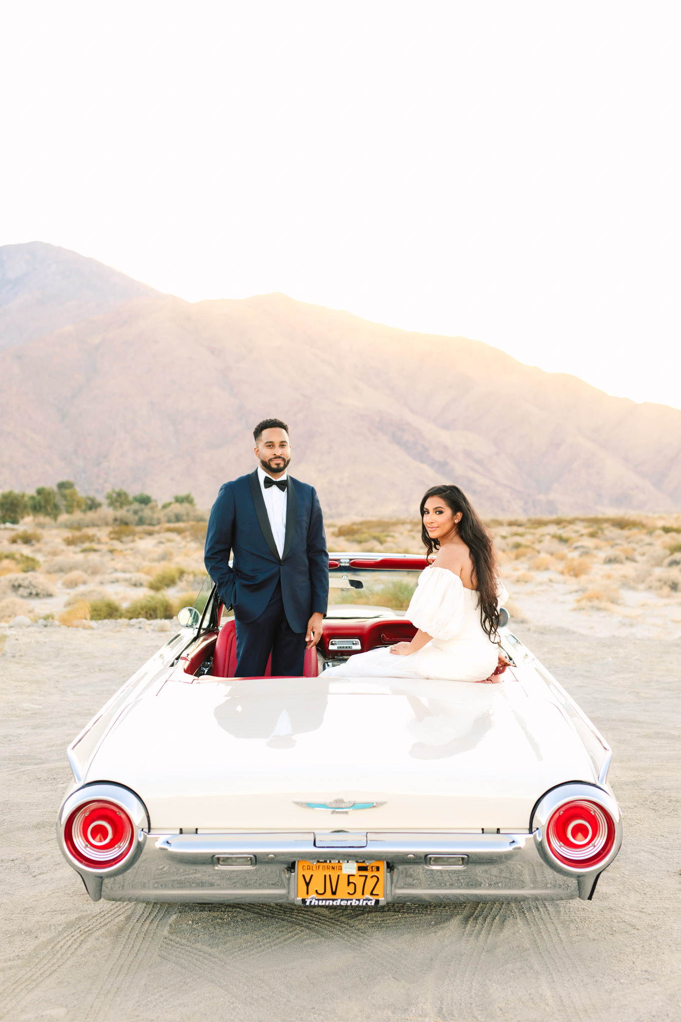 Bride and groom sitting in classic Ford Thunderbird for Palm Springs elopement | Engagement, elopement, and wedding photography roundup of Mary Costa’s favorite images from 2020 | Colorful and elevated photography for fun-loving couples in Southern California | #2020wedding #elopement #weddingphoto #weddingphotography #microwedding   Source: Mary Costa Photography | Los Angeles