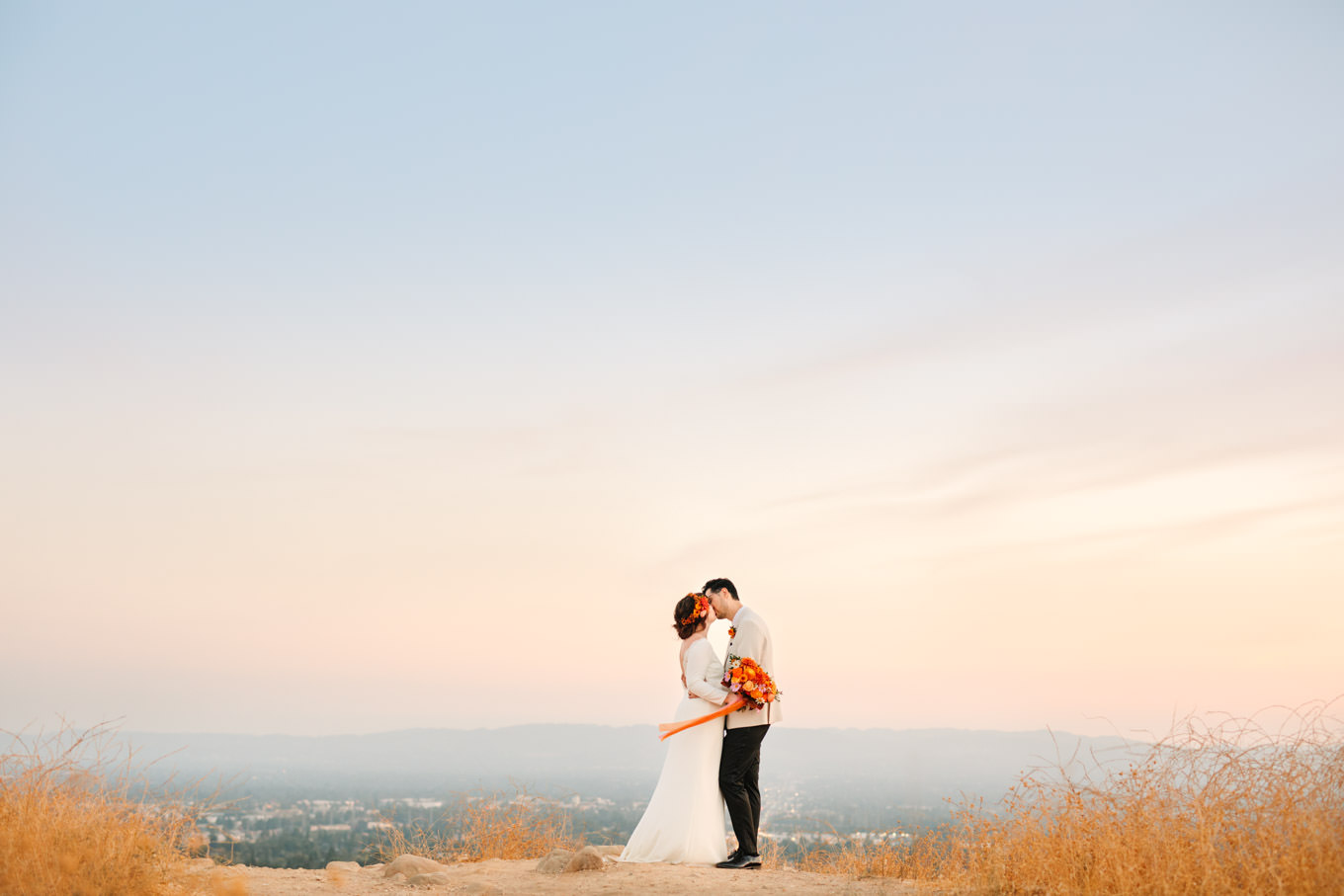 Bride and groom kissing at scenic Los Angeles overlook