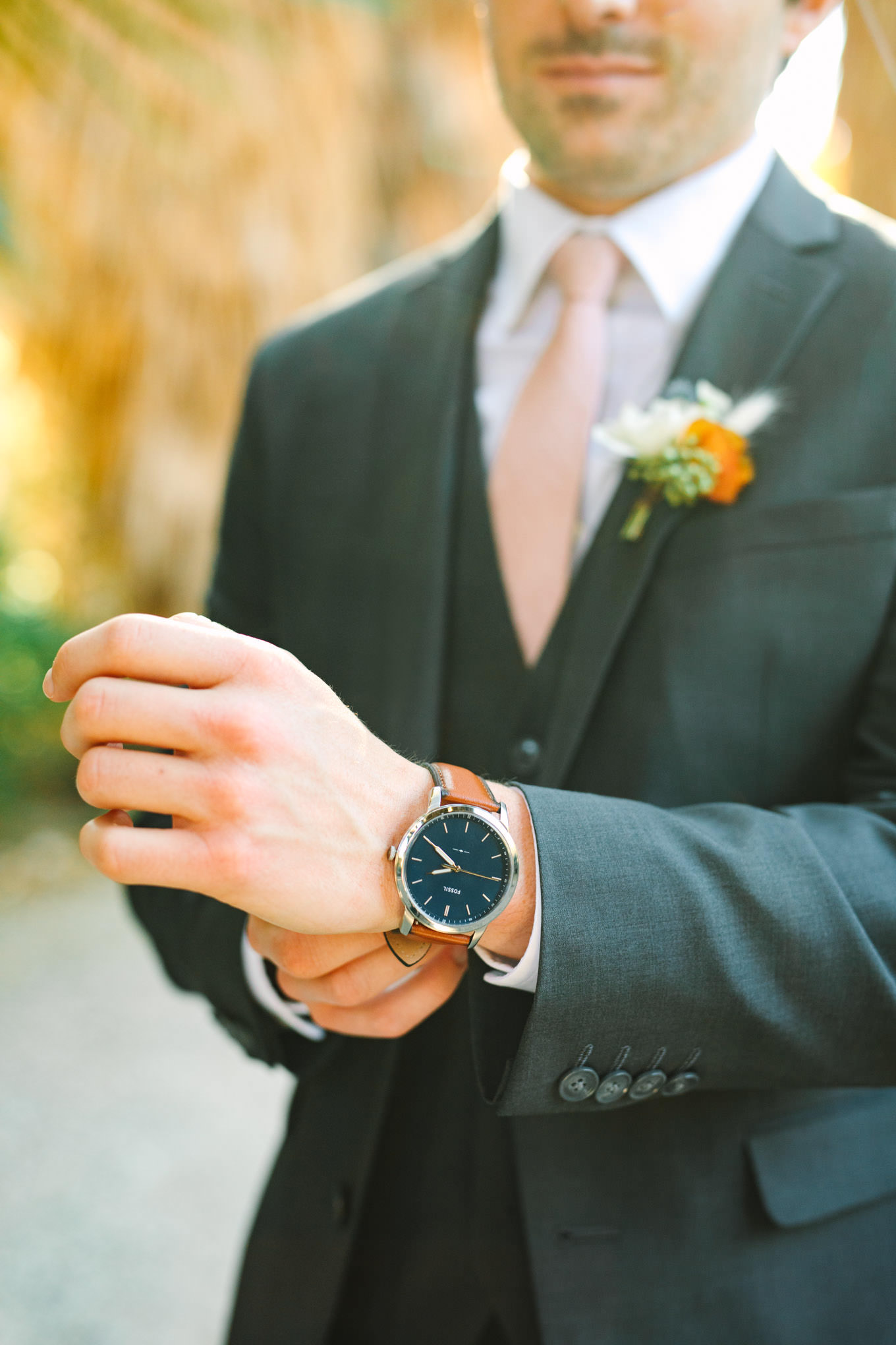 Groom putting on watch | Living Desert Zoo & Gardens wedding with unique details | Elevated and colorful wedding photography for fun-loving couples in Southern California |  #PalmSprings #palmspringsphotographer #gardenwedding #palmspringswedding  Source: Mary Costa Photography | Los Angeles wedding photographer 