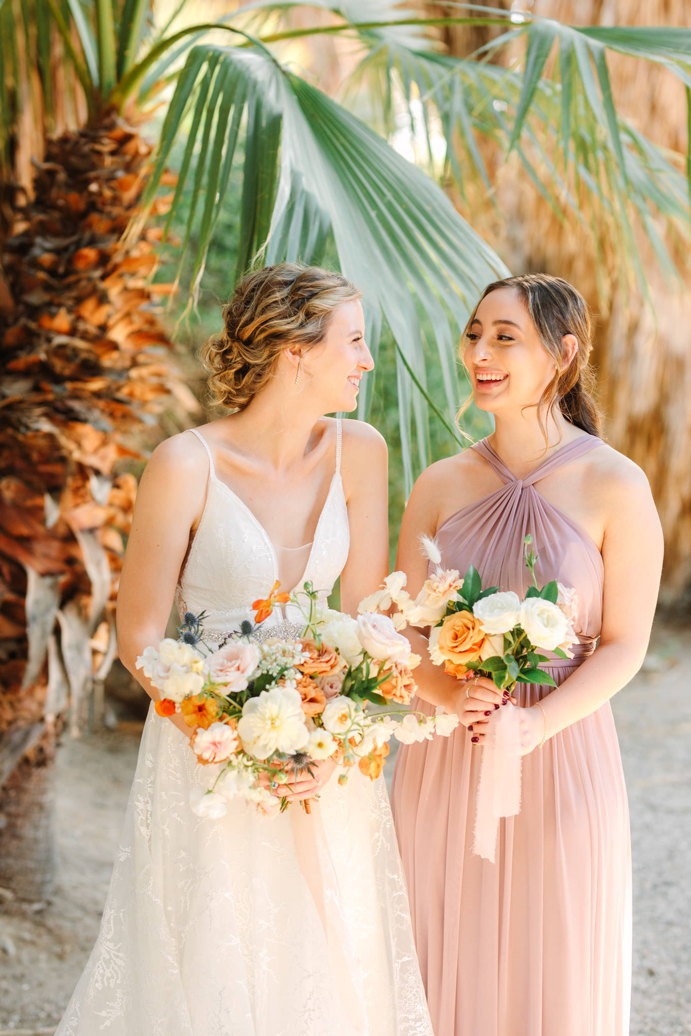 Bride and maid of honor laughing | Living Desert Zoo & Gardens wedding with unique details | Elevated and colorful wedding photography for fun-loving couples in Southern California |  #PalmSprings #palmspringsphotographer #gardenwedding #palmspringswedding  Source: Mary Costa Photography | Los Angeles wedding photographer 