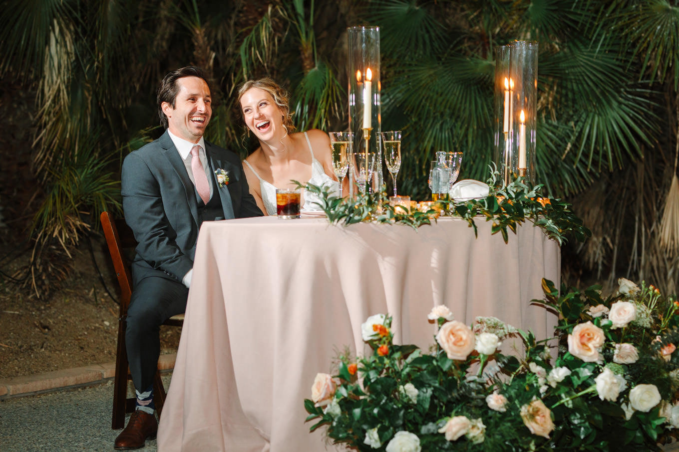 Bride and groom laughing at sweetheart table | Living Desert Zoo & Gardens wedding with unique details | Elevated and colorful wedding photography for fun-loving couples in Southern California |  #PalmSprings #palmspringsphotographer #gardenwedding #palmspringswedding  Source: Mary Costa Photography | Los Angeles wedding photographer 