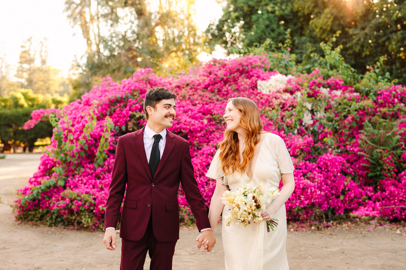 Couple walking away from lush bougainvillea | Los Angeles Arboretum Elopement | Colorful and elevated wedding photography for fun-loving couples in Southern California | #LosAngelesElopement #elopement #LAarboretum #LAskyline #elopementphotos   Source: Mary Costa Photography | Los Angeles