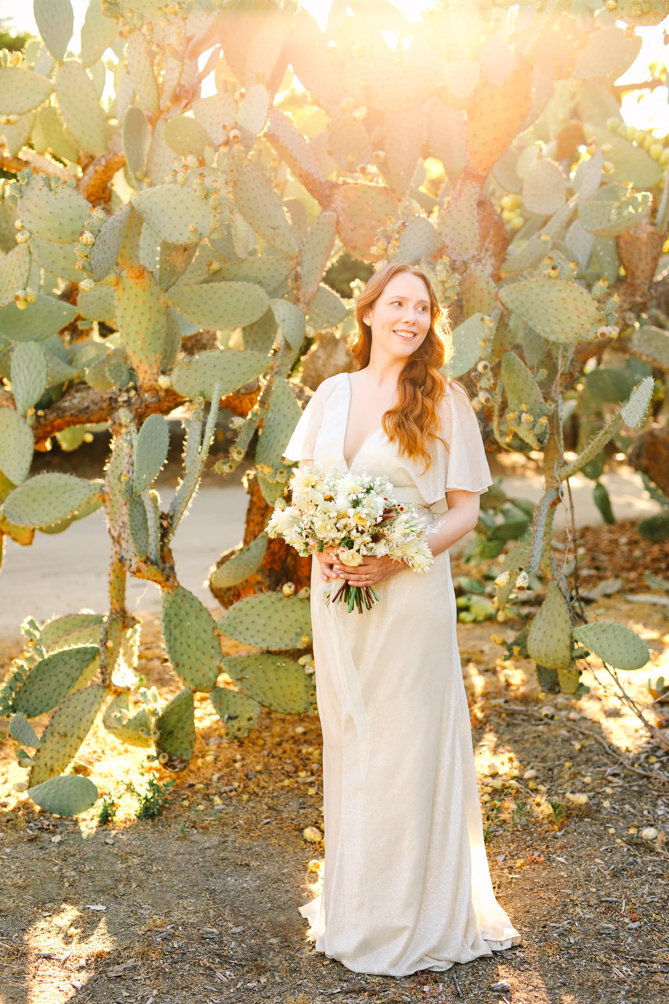 Bride in Jenny Yoo v-neck dress in front of cacti plants | Los Angeles Arboretum Elopement | Colorful and elevated wedding photography for fun-loving couples in Southern California | #LosAngelesElopement #elopement #LAarboretum #LAskyline #elopementphotos   Source: Mary Costa Photography | Los Angeles