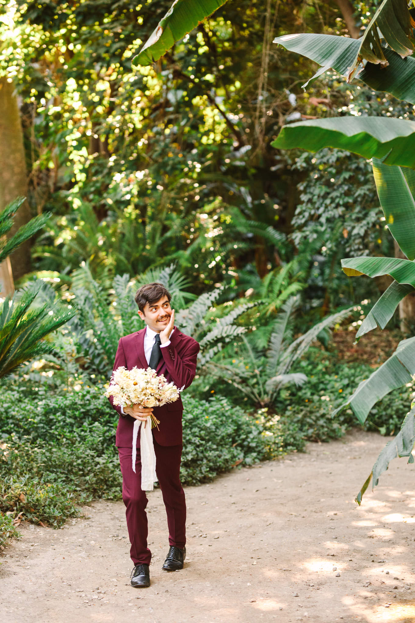Groom walking with the bride's bouquet | Los Angeles Arboretum Elopement | Colorful and elevated wedding photography for fun-loving couples in Southern California | #LosAngelesElopement #elopement #LAarboretum #LAskyline #elopementphotos   Source: Mary Costa Photography | Los Angeles