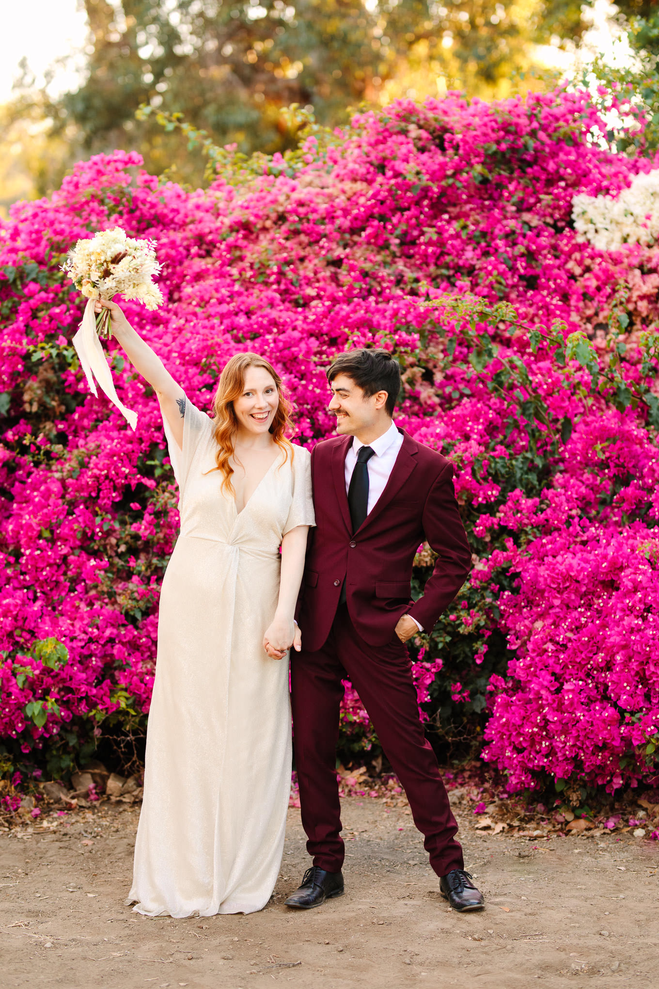 Playful bride and groom in front of lush bougainvillea | Los Angeles Arboretum Elopement | Colorful and elevated wedding photography for fun-loving couples in Southern California | #LosAngelesElopement #elopement #LAarboretum #LAskyline #elopementphotos   Source: Mary Costa Photography | Los Angeles