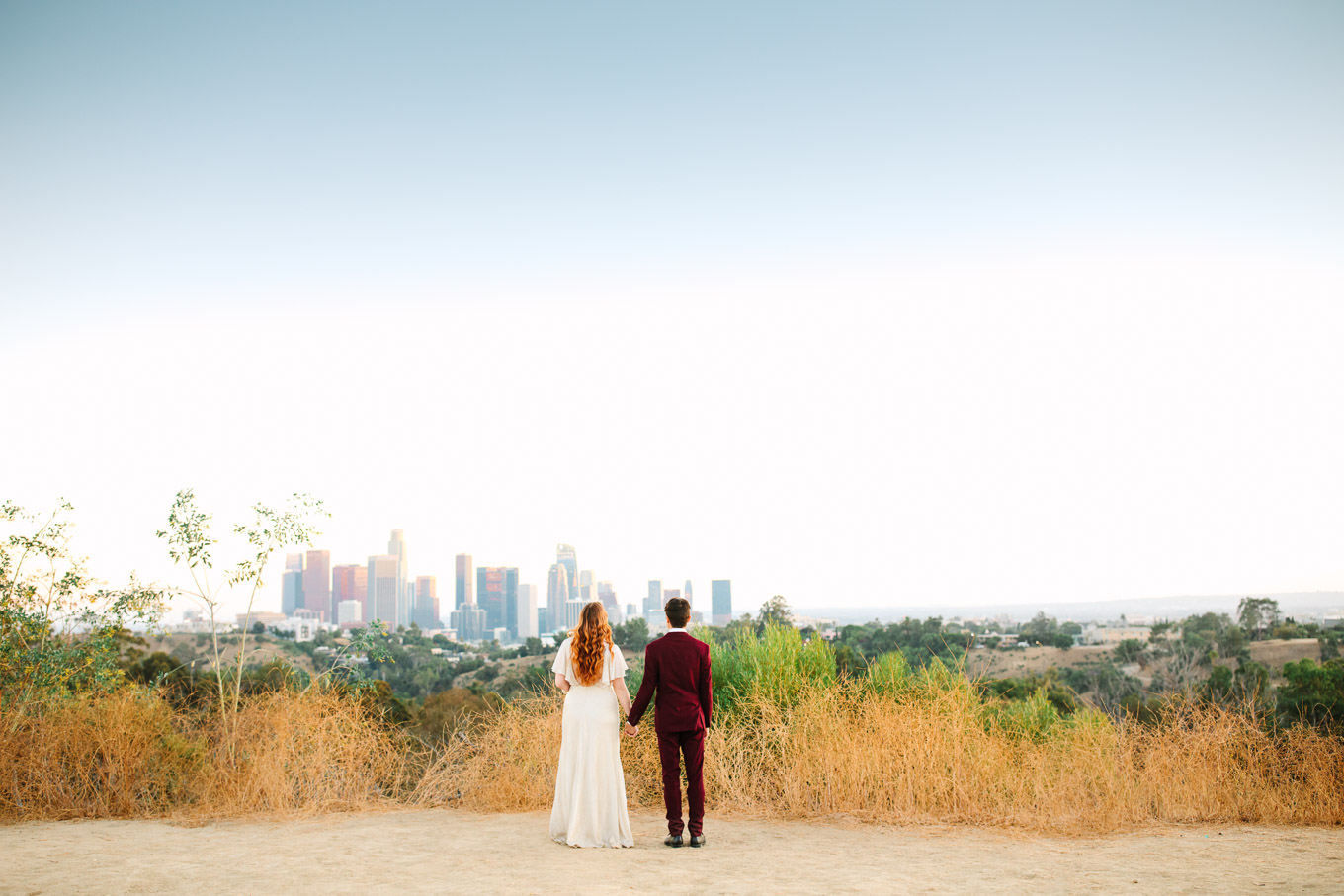 Couple in front of LA skyline | Los Angeles Elysian Park Elopement | Colorful and elevated wedding photography for fun-loving couples in Southern California | #LosAngelesElopement #elopement #LAarboretum #LAskyline #elopementphotos   Source: Mary Costa Photography | Los Angeles