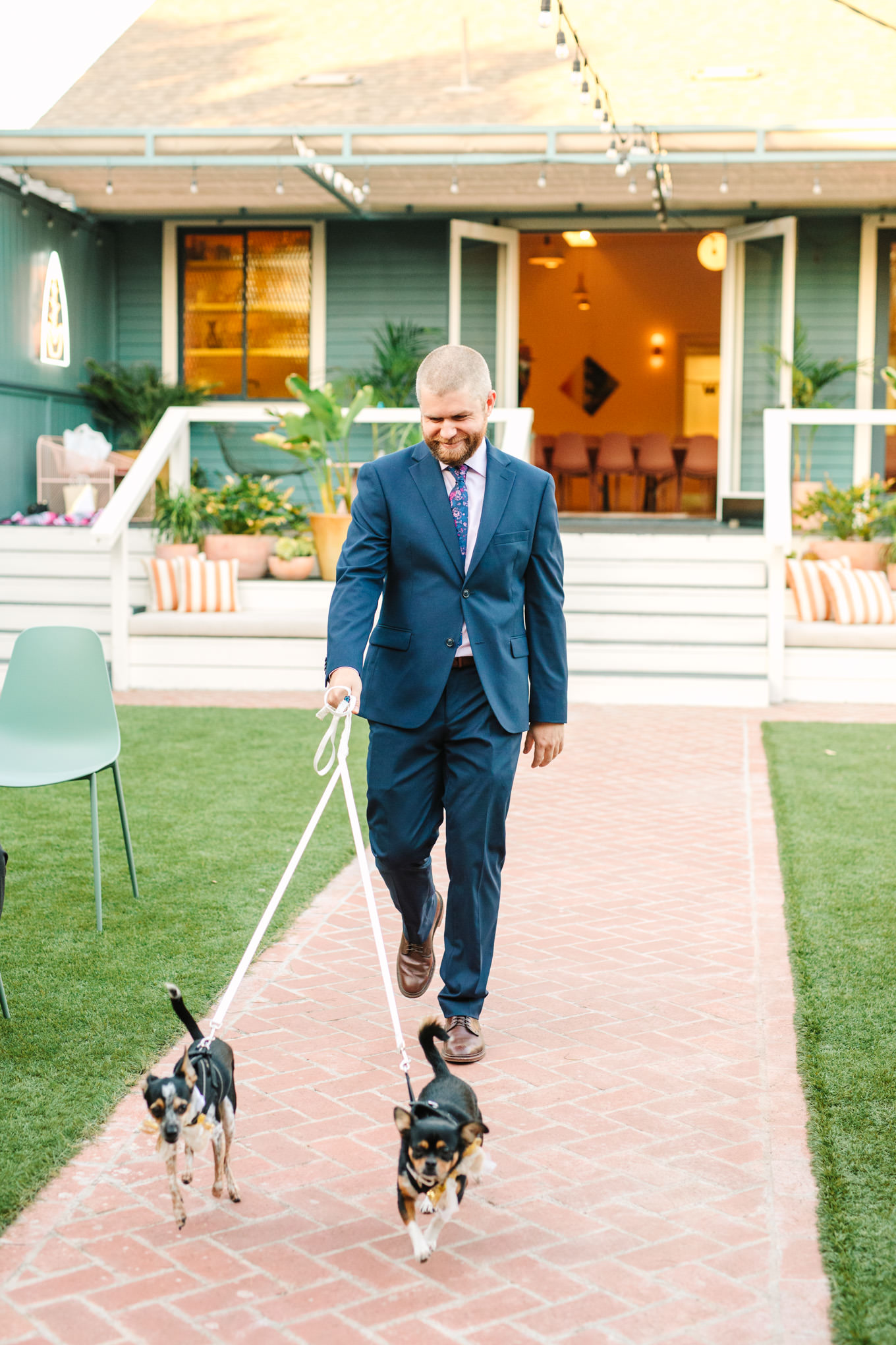 Best man walking down puppies to wedding ceremony | Colorful pop-up micro wedding at The Ruby Street Los Angeles featured on Green Wedding Shoes | Colorful and elevated photography for fun-loving couples in Southern California | #colorfulwedding #popupwedding #weddingphotography #microwedding Source: Mary Costa Photography | Los Angeles