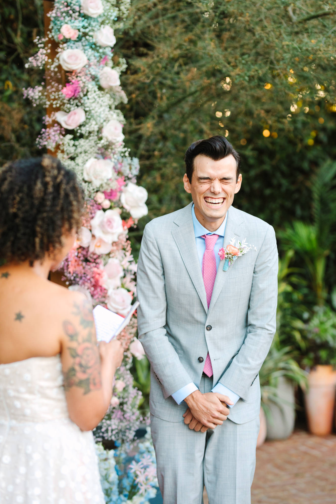 Groom laughing during wedding ceremony | Colorful pop-up micro wedding at The Ruby Street Los Angeles featured on Green Wedding Shoes | Colorful and elevated photography for fun-loving couples in Southern California | #colorfulwedding #popupwedding #weddingphotography #microwedding Source: Mary Costa Photography | Los Angeles