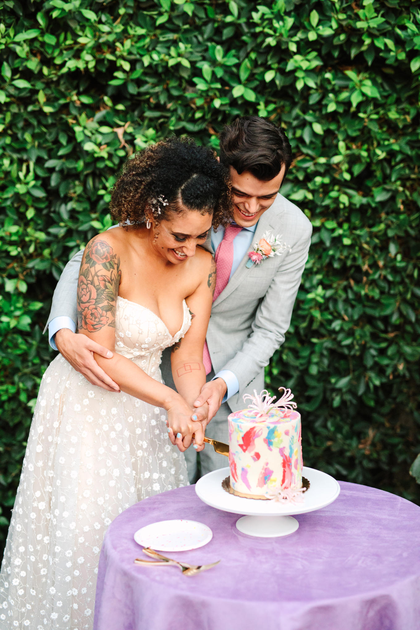 Bride and groom cutting colorful watercolor taro cake by Flouring LA | Colorful pop-up micro wedding at The Ruby Street Los Angeles featured on Green Wedding Shoes | Colorful and elevated photography for fun-loving couples in Southern California | #colorfulwedding #popupwedding #weddingphotography #microwedding Source: Mary Costa Photography | Los Angeles