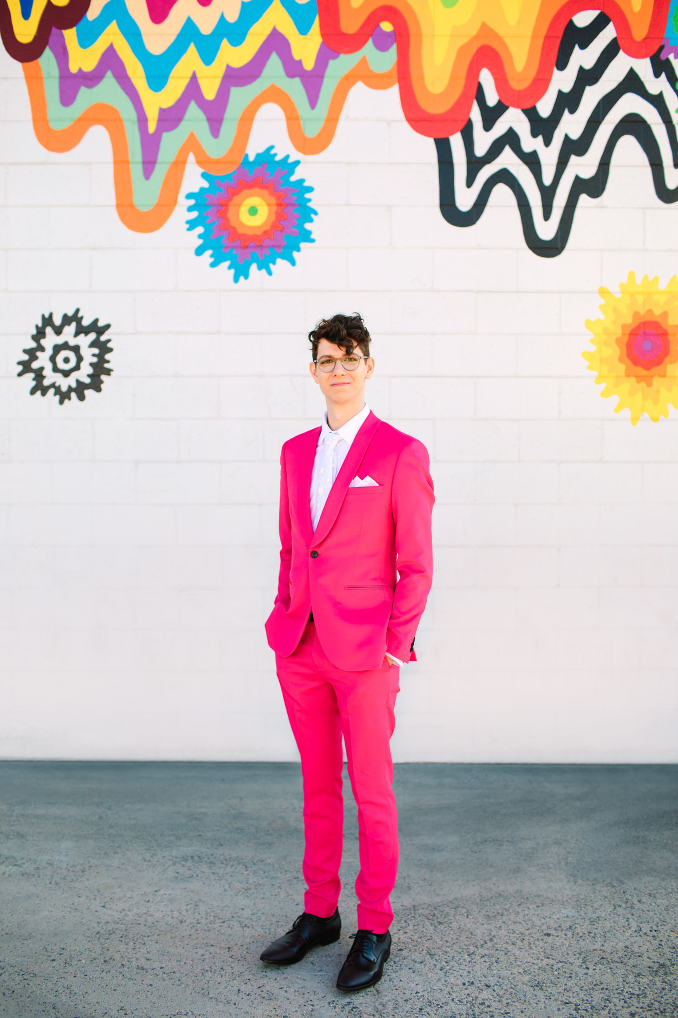 Groom in hot pink suit in front of rainbow mural DTLA | Colorful wedding at The Unique Space Los Angeles published in The Knot Magazine | Fresh and colorful photography for fun-loving couples in Southern California | #colorfulwedding #popupwedding #weddingphotography #microwedding Source: Mary Costa Photography | Los Angeles