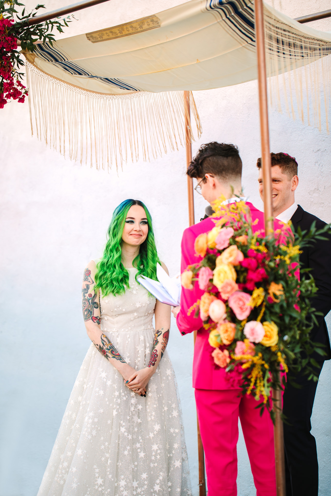 Bride with green hair listening to wedding vows | Colorful wedding at The Unique Space Los Angeles published in The Knot Magazine | Fresh and colorful photography for fun-loving couples in Southern California | #colorfulwedding #losangeleswedding #weddingphotography #uniquespace Source: Mary Costa Photography | Los Angeles