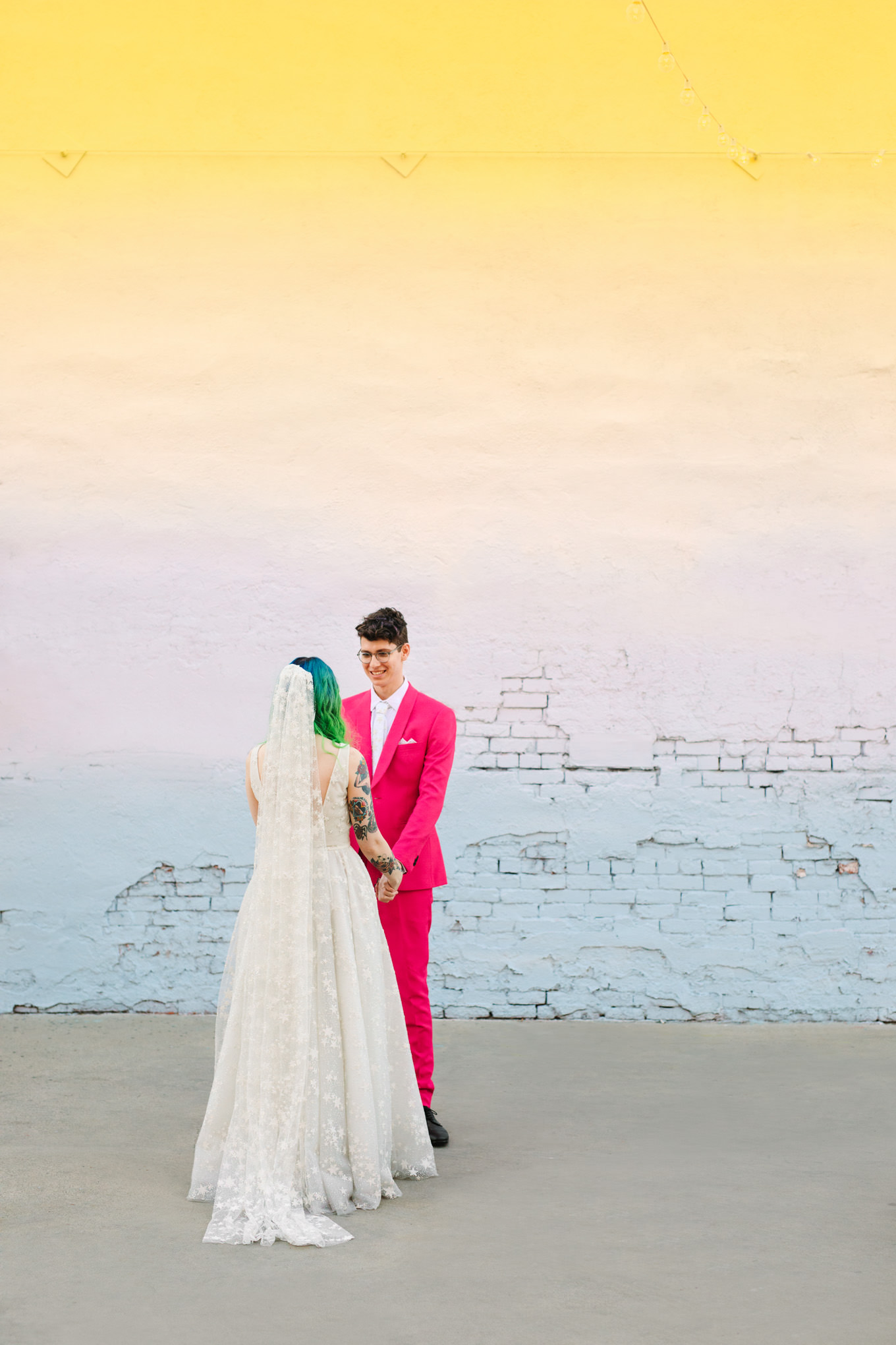 Bride and groom against ombre wall