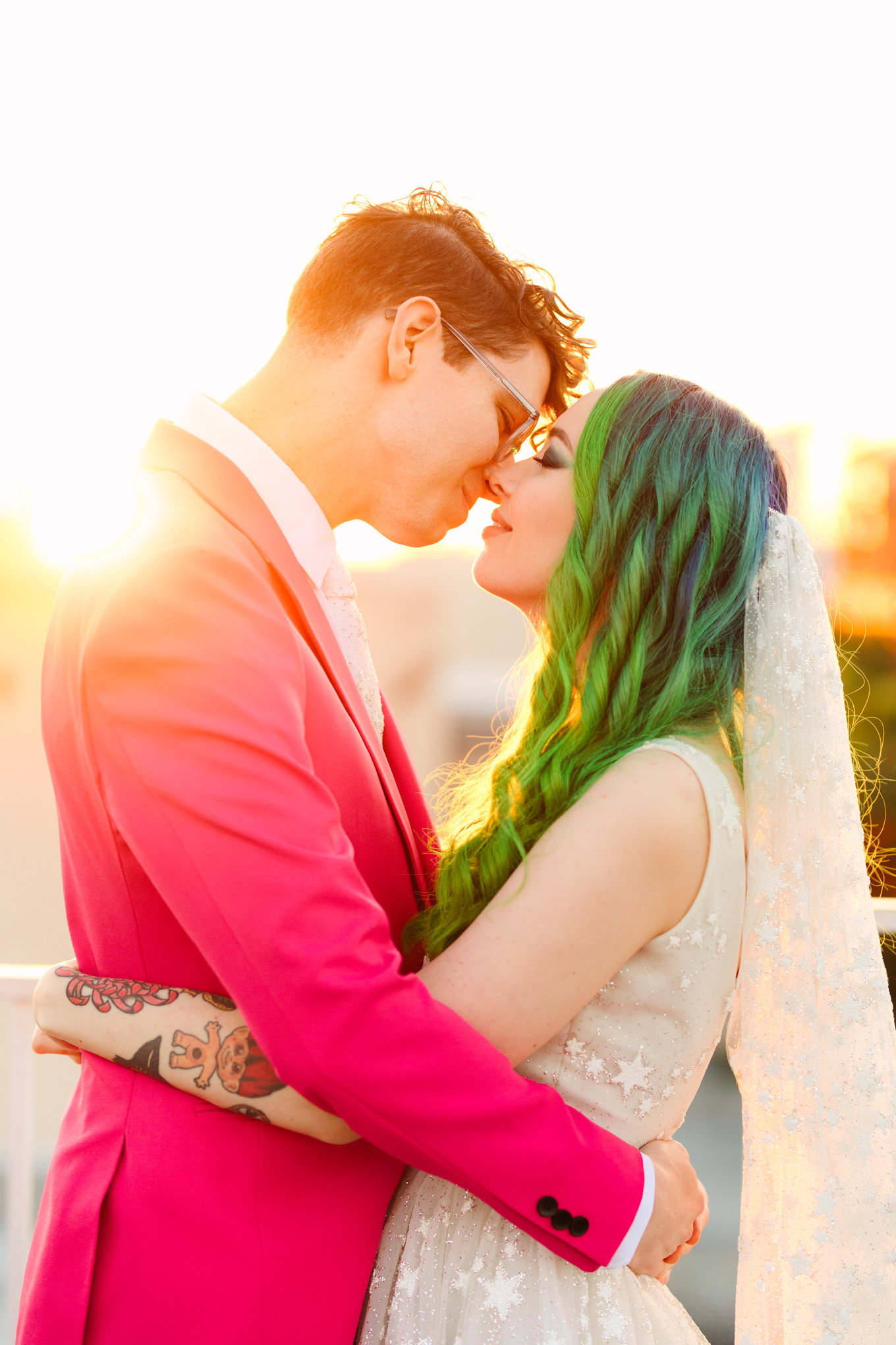 Sunset portraits on rooftop with green hair bride in star gown and groom in hot pink suit | Colorful wedding at The Unique Space Los Angeles published in The Knot Magazine | Fresh and colorful photography for fun-loving couples in Southern California | #colorfulwedding #losangeleswedding #weddingphotography #uniquespace Source: Mary Costa Photography | Los Angeles