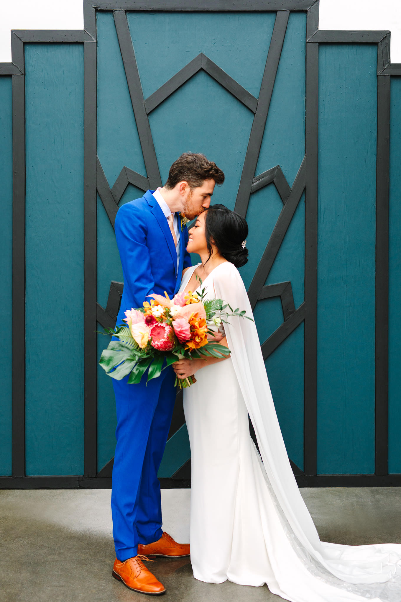 Bride and groom in front of teal geometric gate | TV inspired wedding at The Fig House Los Angeles | Published on The Knot | Fresh and colorful photography for fun-loving couples in Southern California | #losangeleswedding #TVwedding #colorfulwedding #theknot   Source: Mary Costa Photography | Los Angeles wedding photographer