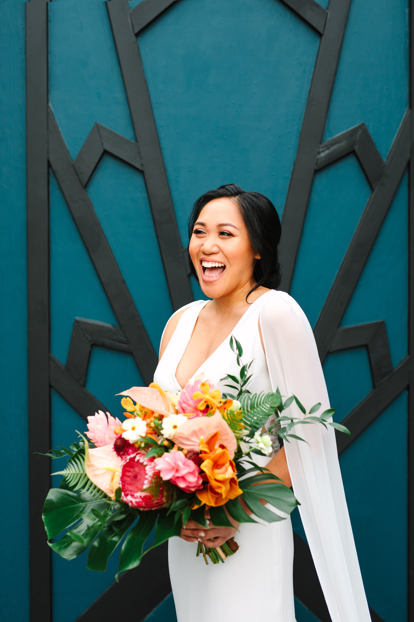 Bride laughing in front of teal geometric wall | TV inspired wedding at The Fig House Los Angeles | Published on The Knot | Fresh and colorful photography for fun-loving couples in Southern California | #losangeleswedding #TVwedding #colorfulwedding #theknot   Source: Mary Costa Photography | Los Angeles wedding photographer