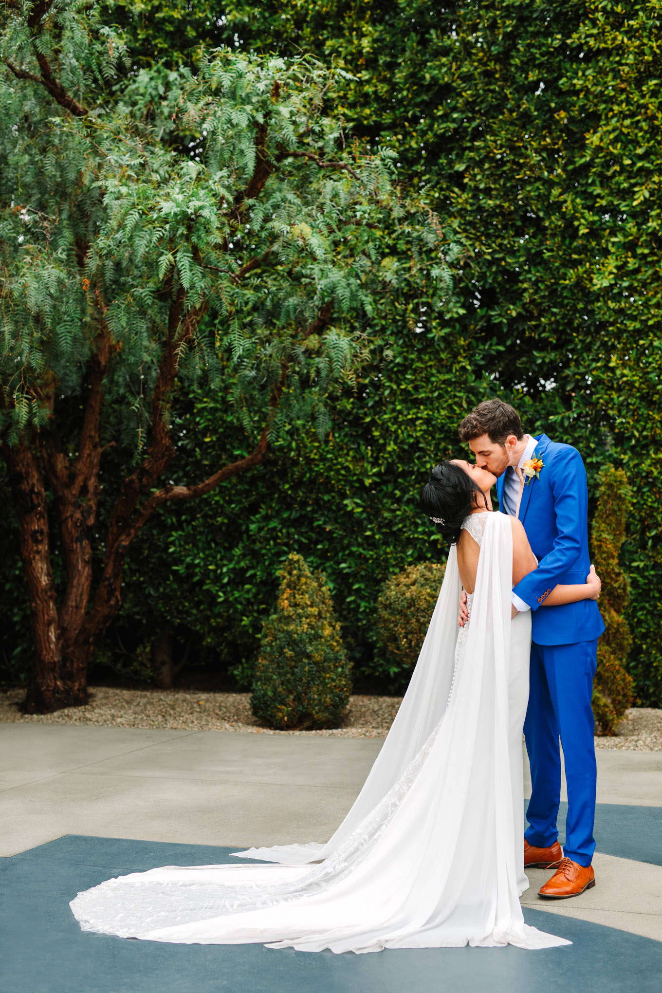 Bride in cape dress kissing | TV inspired wedding at The Fig House Los Angeles | Published on The Knot | Fresh and colorful photography for fun-loving couples in Southern California | #losangeleswedding #TVwedding #colorfulwedding #theknot   Source: Mary Costa Photography | Los Angeles wedding photographer