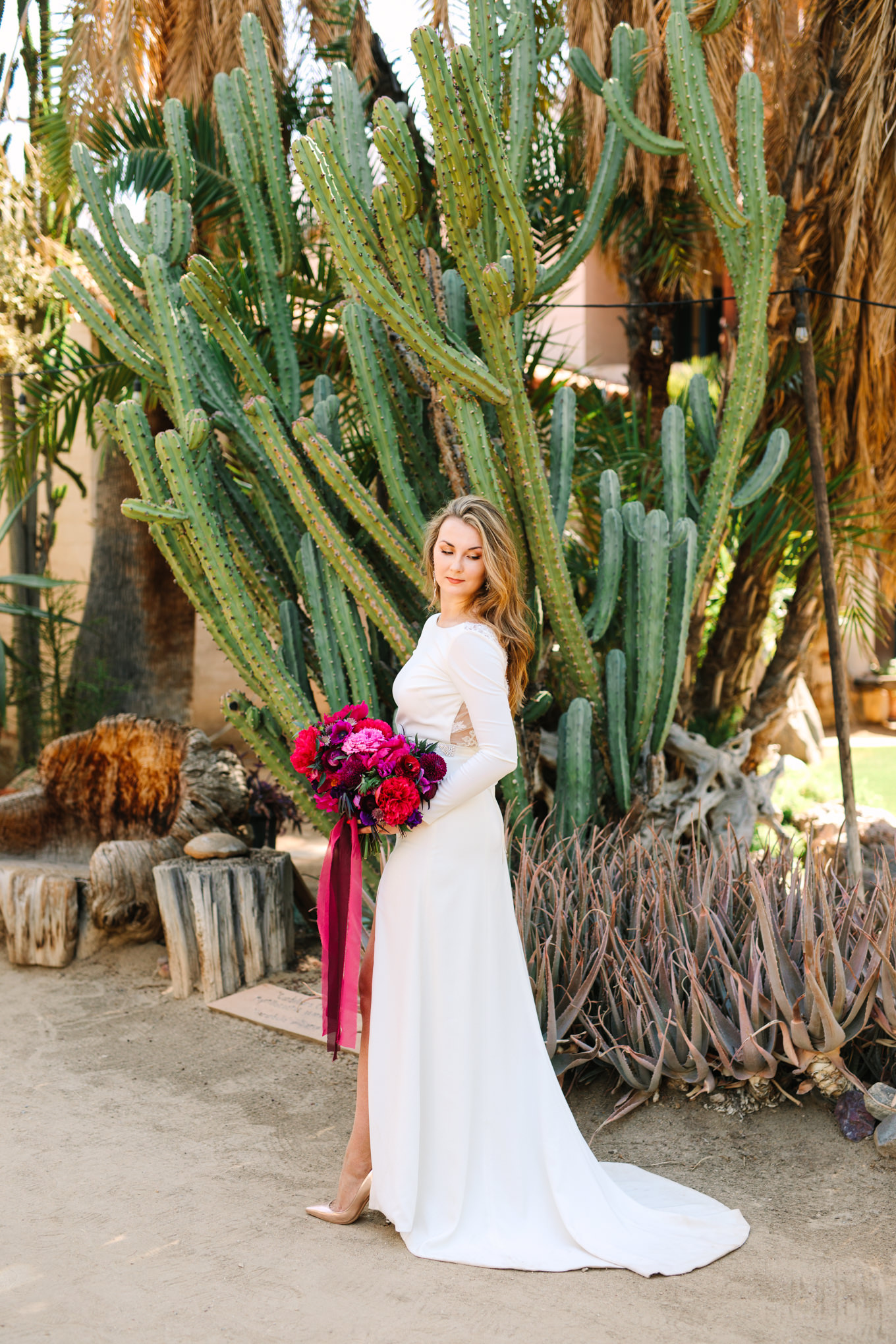Bride in long sleeve dress with cacti | Colorful jewel tone Palm Springs elopement | Fresh and colorful photography for fun-loving couples in Southern California | #colorfulelopement #palmspringselopement #elopementphotography #palmspringswedding Source: Mary Costa Photography | Los Angeles