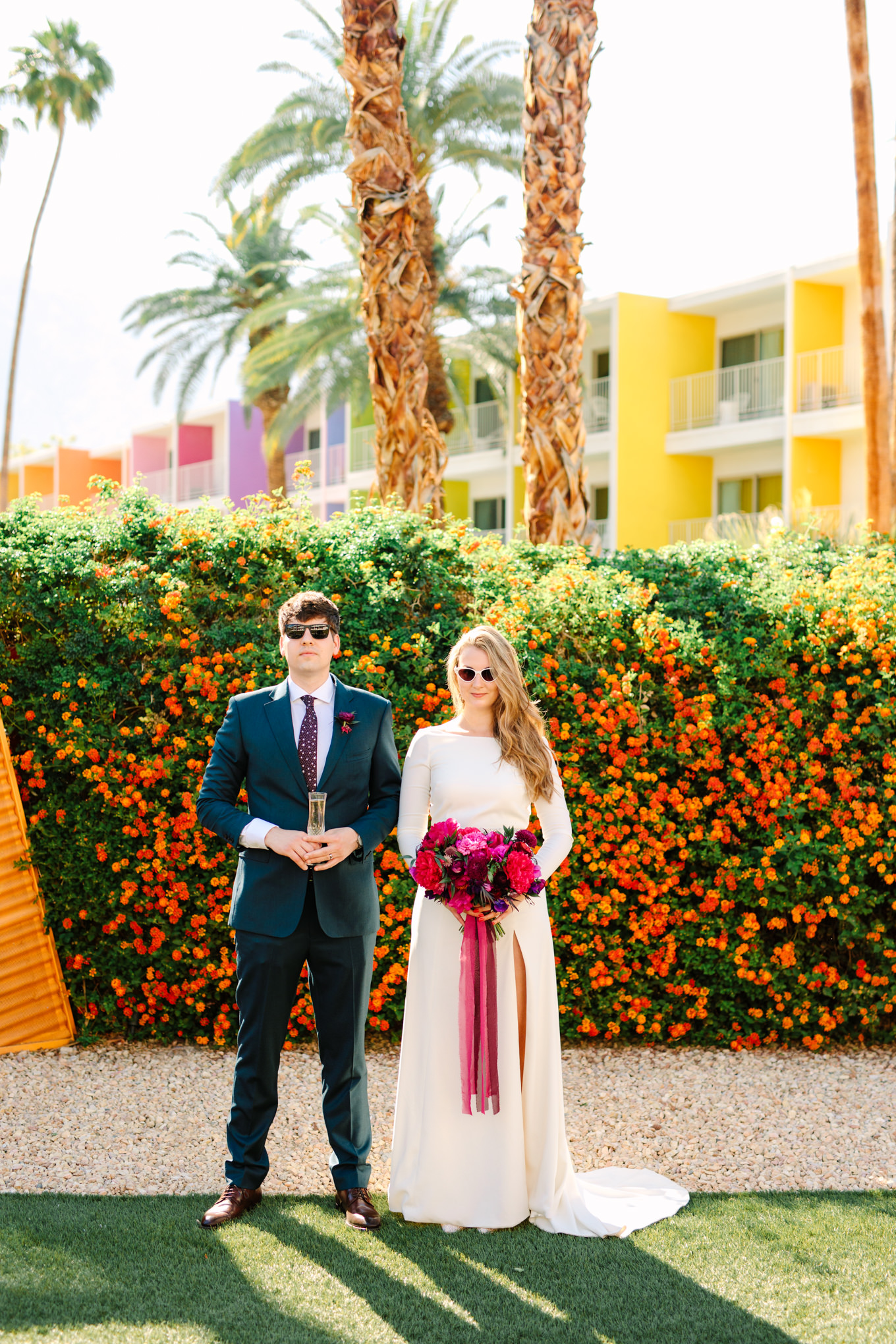 Bride and groom drinking champagne at Saguaro Palm Springs | Colorful jewel tone Palm Springs elopement | Fresh and colorful photography for fun-loving couples in Southern California | #colorfulelopement #palmspringselopement #elopementphotography #palmspringswedding Source: Mary Costa Photography | Los Angeles