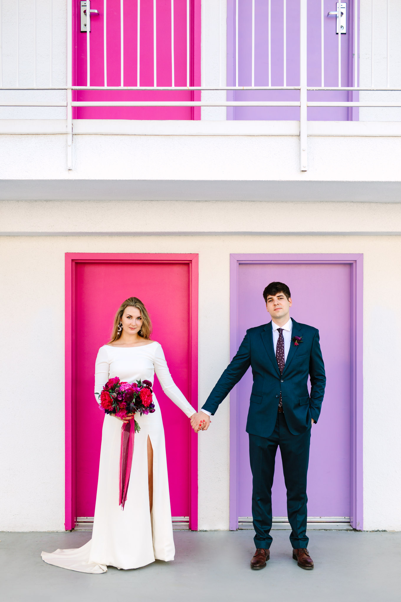 Bride and groom in front of Saguaro Hotel doors | Colorful jewel tone Palm Springs elopement | Fresh and colorful photography for fun-loving couples in Southern California | #colorfulelopement #palmspringselopement #elopementphotography #palmspringswedding Source: Mary Costa Photography | Los Angeles