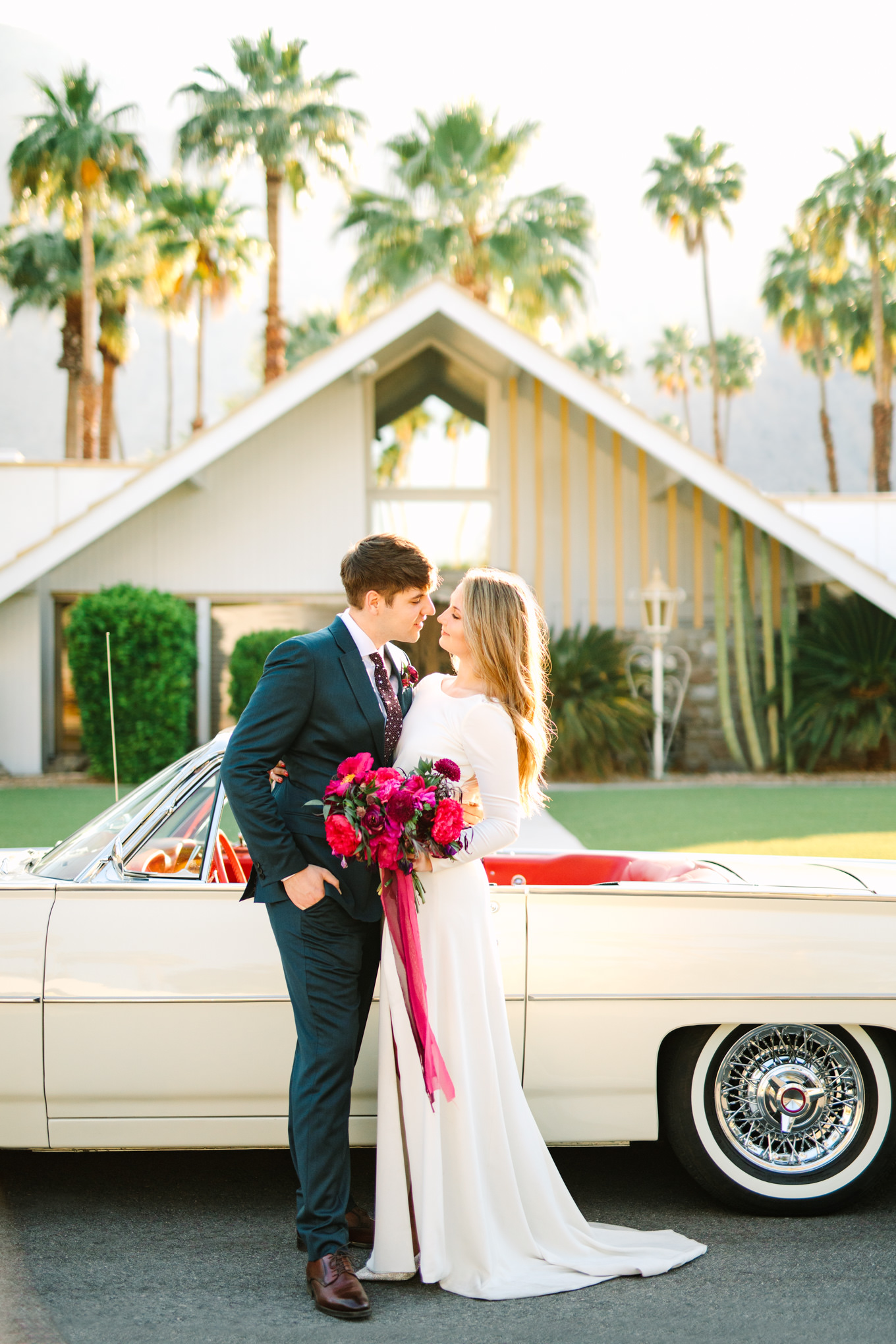 Bride and groom with classic car in Mid Century Modern neighborhood | Colorful jewel tone Palm Springs elopement | Fresh and colorful photography for fun-loving couples in Southern California | #colorfulelopement #palmspringselopement #elopementphotography #palmspringswedding Source: Mary Costa Photography | Los Angeles