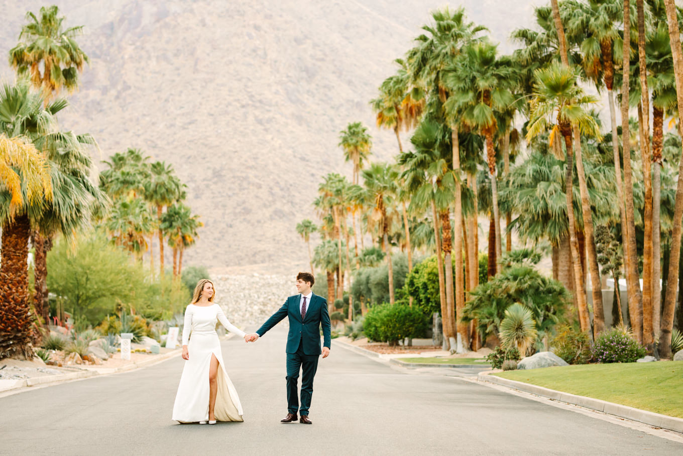 Bride and groom walking in palm tree lined street | Colorful jewel tone Palm Springs elopement | Fresh and colorful photography for fun-loving couples in Southern California | #colorfulelopement #palmspringselopement #elopementphotography #palmspringswedding Source: Mary Costa Photography | Los Angeles