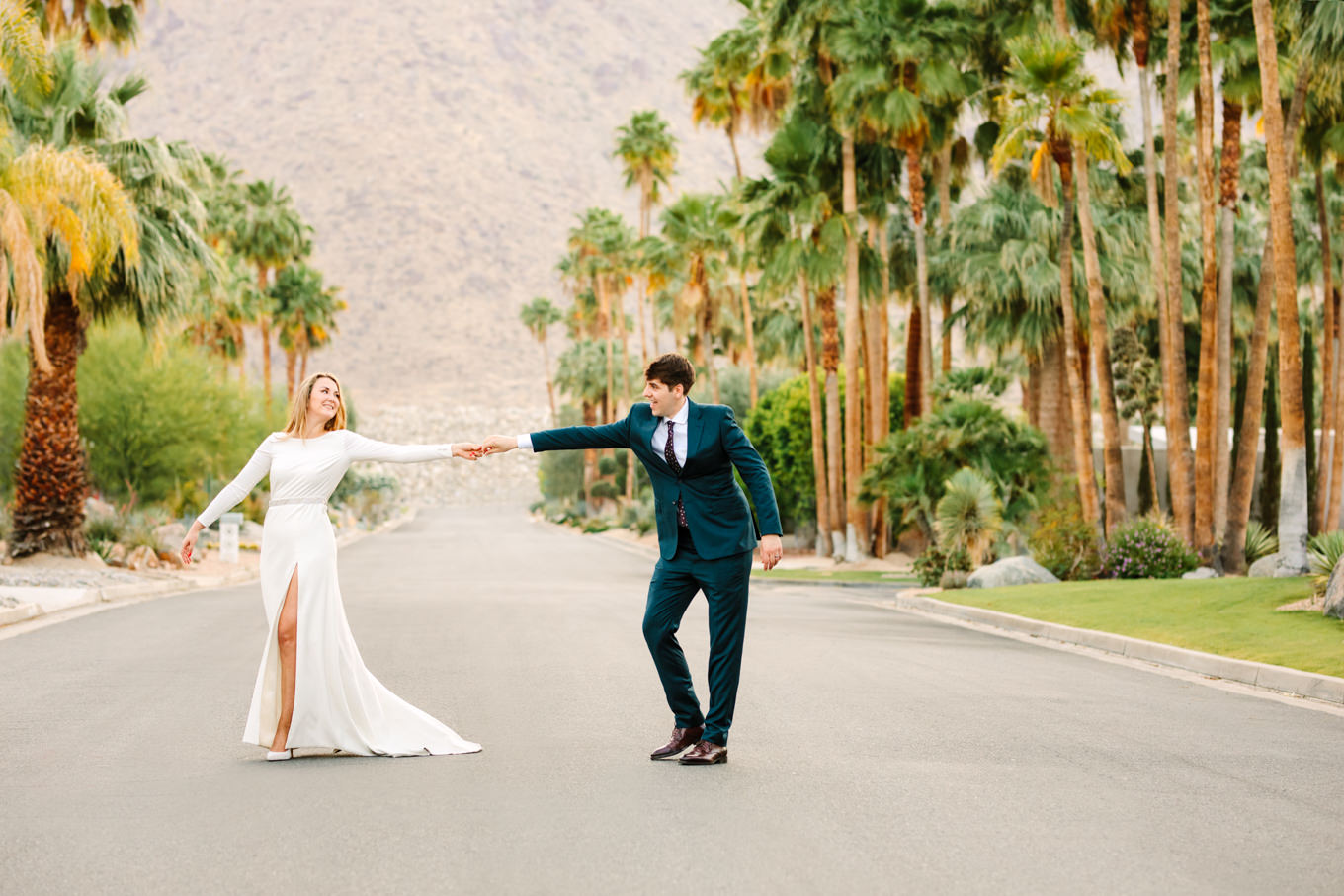 Bride and groom dancing in palm tree lined street | Colorful jewel tone Palm Springs elopement | Fresh and colorful photography for fun-loving couples in Southern California | #colorfulelopement #palmspringselopement #elopementphotography #palmspringswedding Source: Mary Costa Photography | Los Angeles