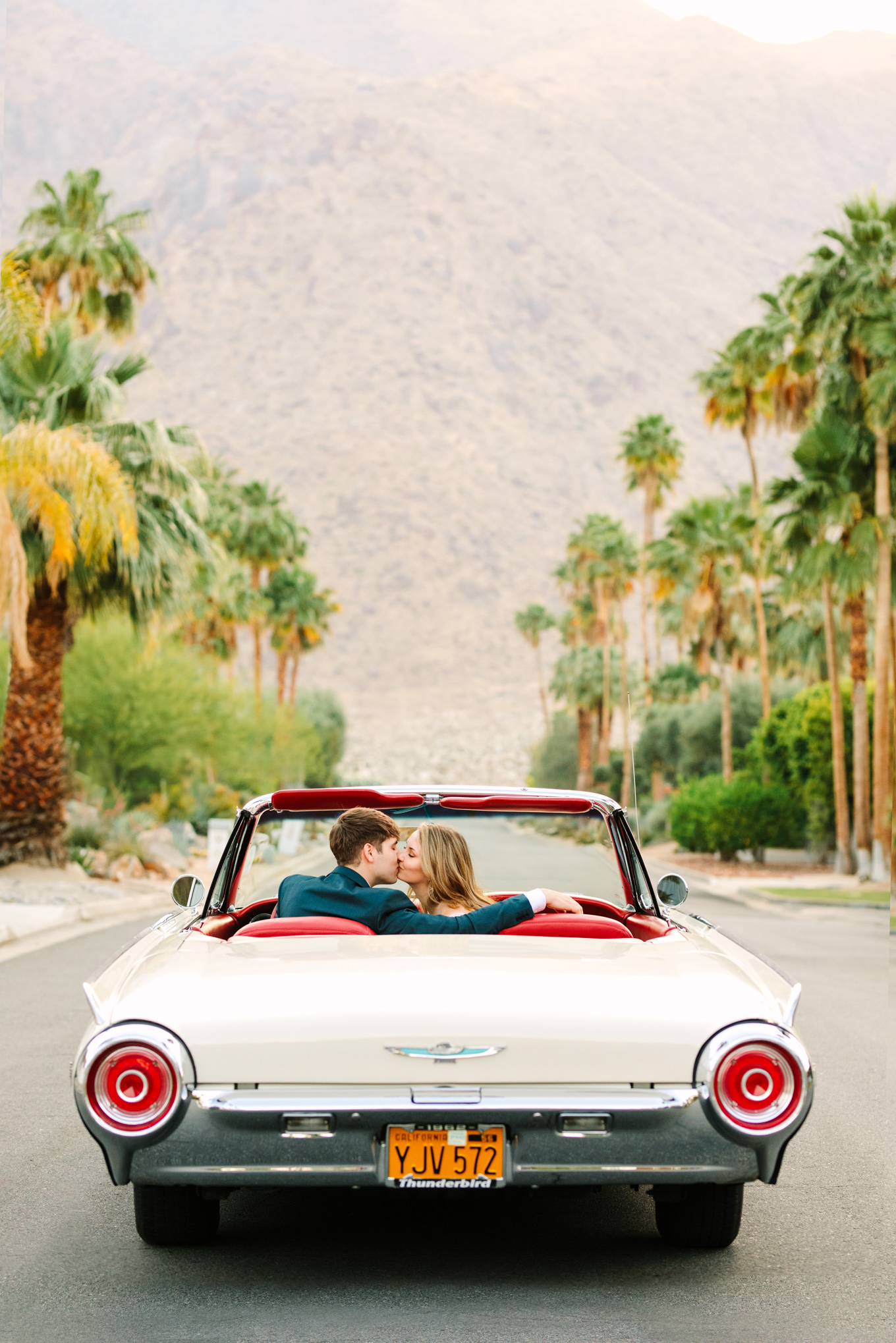 Bride and groom with classic car in Mid Century Modern neighborhood | Colorful jewel tone Palm Springs elopement | Fresh and colorful photography for fun-loving couples in Southern California | #colorfulelopement #palmspringselopement #elopementphotography #palmspringswedding Source: Mary Costa Photography | Los Angeles