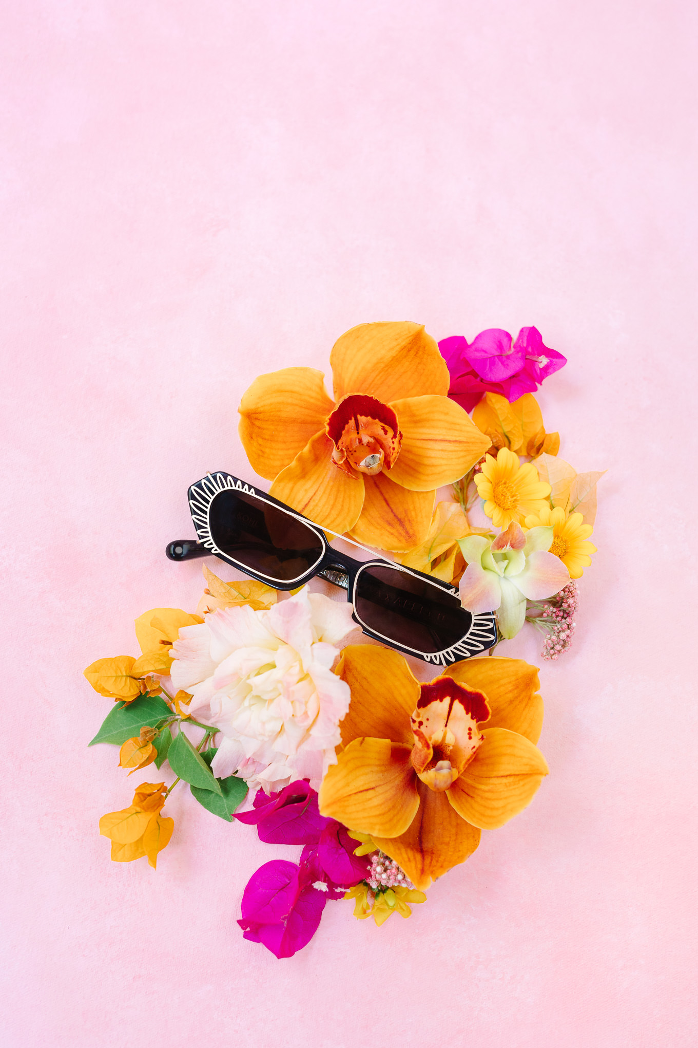 Funky black sunglasses in floral flatlay | Kindred Presets x Mary Costa Photography Sands Hotel Ad Campaign | Colorful Palm Springs wedding photography | #palmspringsphotographer #lightroompresets #sandshotel #pinkhotel   Source: Mary Costa Photography | Los Angeles