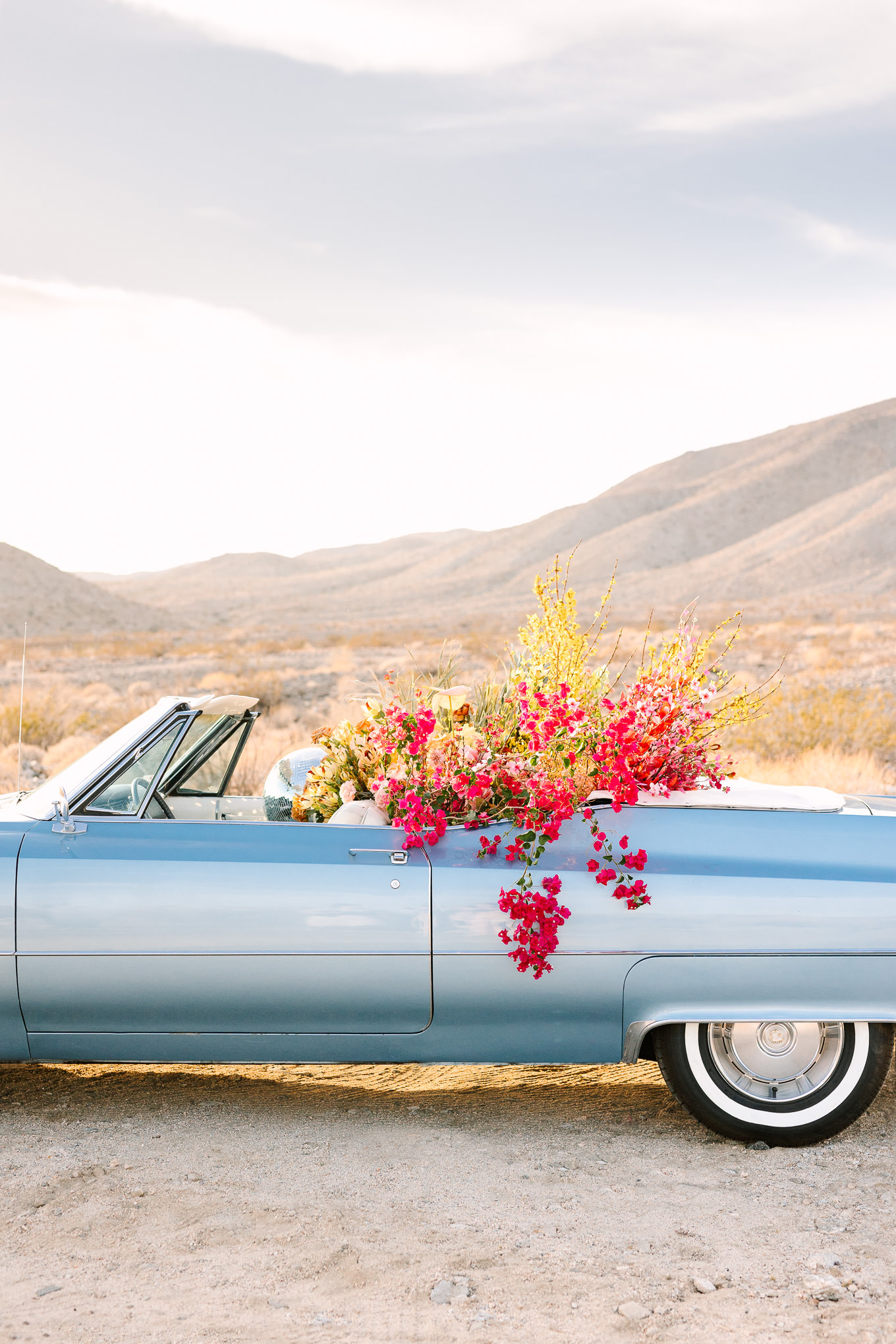 Blue classic Cadillac filled with flowers and disco balls | Kindred Presets x Mary Costa Photography Palm Springs Ad Campaign | Colorful Palm Springs wedding photography | #palmspringsphotographer #lightroompresets #sandshotel #pinkhotel   Source: Mary Costa Photography | Los Angeles