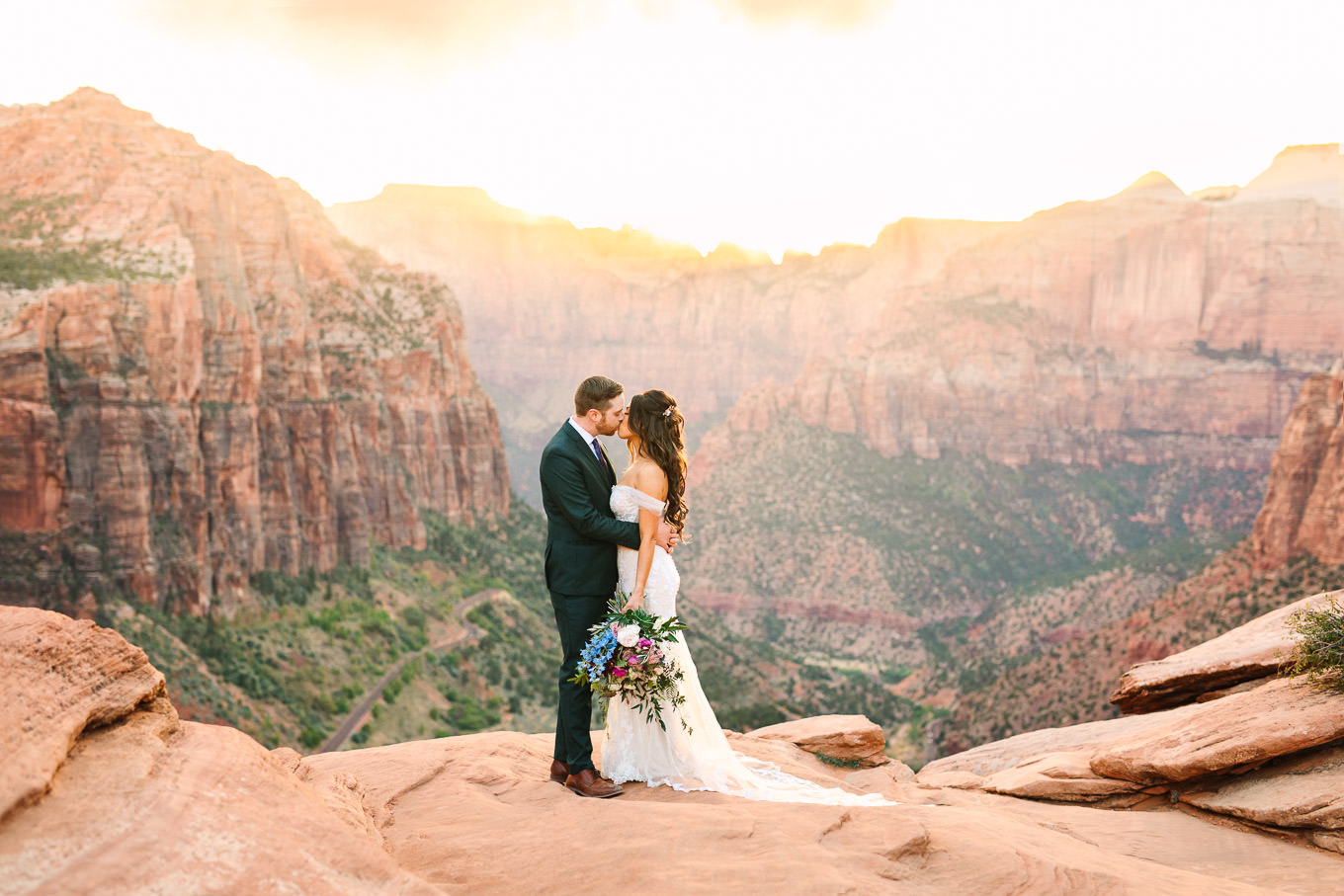 Bride and groom on cliff | Zion National Park sunset elopement scenic overlook | Colorful adventure elopement photography | #utahelopement #zionelopement #zionwedding #undercanvaszion   Source: Mary Costa Photography | Los Angeles
