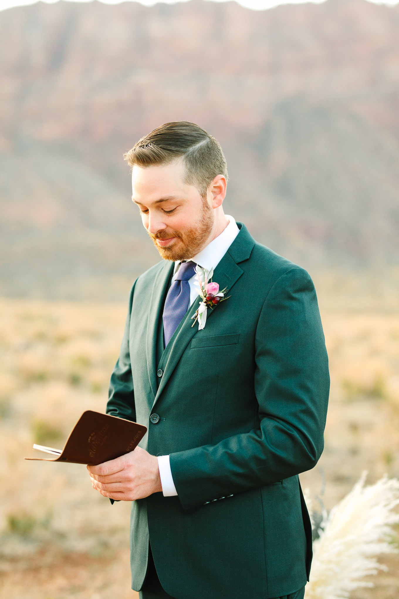 Groom reading vows | Zion Under Canvas camping elopement at sunrise | Colorful elopement photography | #utahelopement #zionelopement #zionwedding #undercanvaszion #sunriseelopement #adventureelopement  Source: Mary Costa Photography | Los Angeles