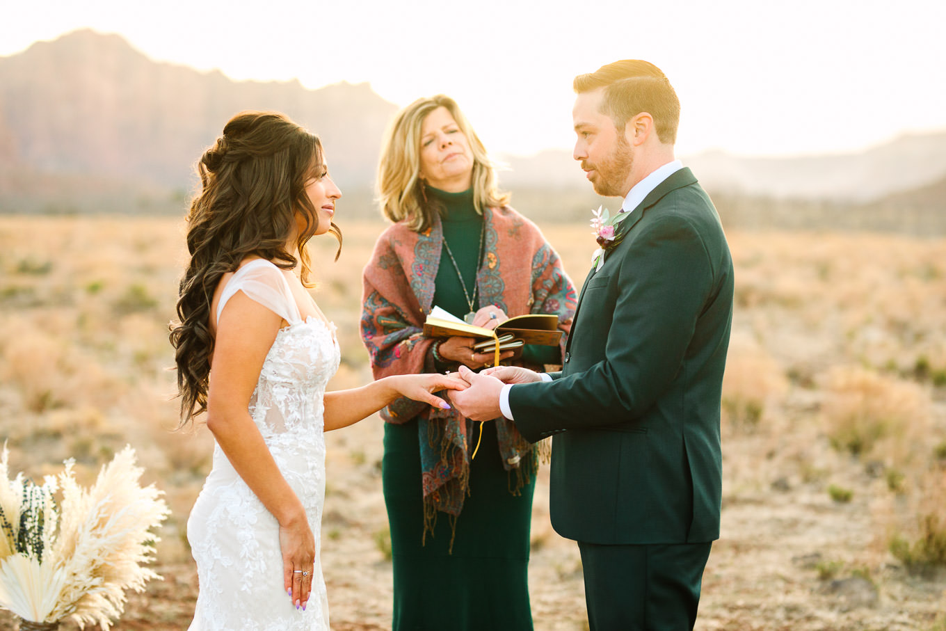 Bride and groom wedding ring exchange | Zion Under Canvas camping elopement at sunrise | Colorful elopement photography | #utahelopement #zionelopement #zionwedding #undercanvaszion #sunriseelopement #adventureelopement  Source: Mary Costa Photography | Los Angeles