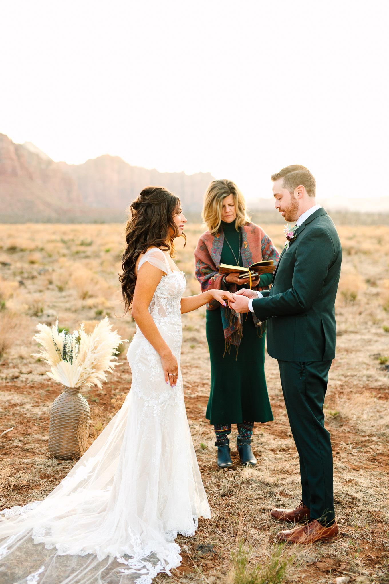 Bride and groom wedding ring exchange | Zion Under Canvas camping elopement at sunrise | Colorful elopement photography | #utahelopement #zionelopement #zionwedding #undercanvaszion #sunriseelopement #adventureelopement  Source: Mary Costa Photography | Los Angeles