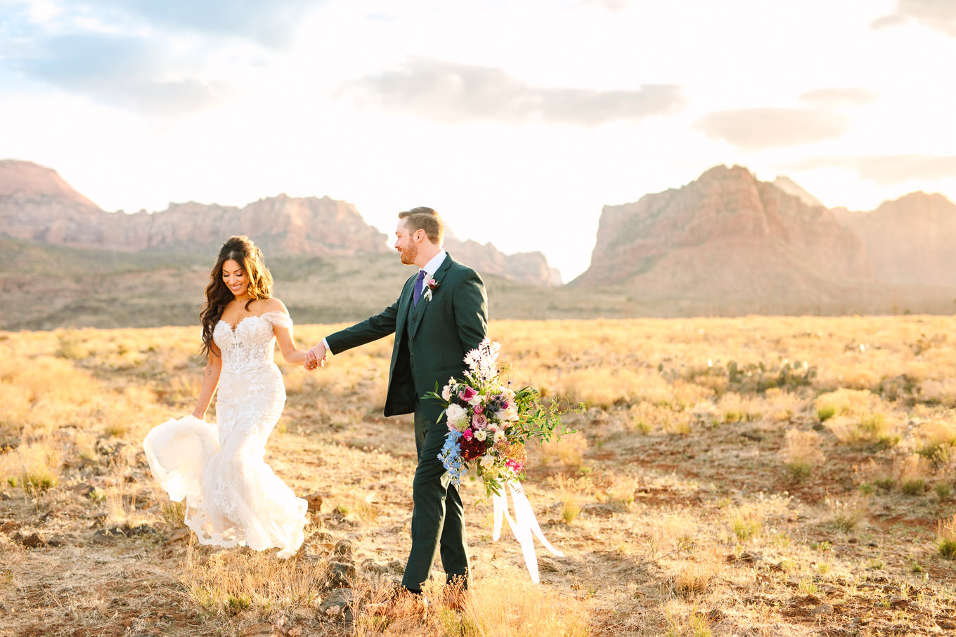 Bride and groom walking | Zion Under Canvas camping elopement at sunrise | Colorful elopement photography | #utahelopement #zionelopement #zionwedding #undercanvaszion #sunriseelopement #adventureelopement  Source: Mary Costa Photography | Los Angeles
