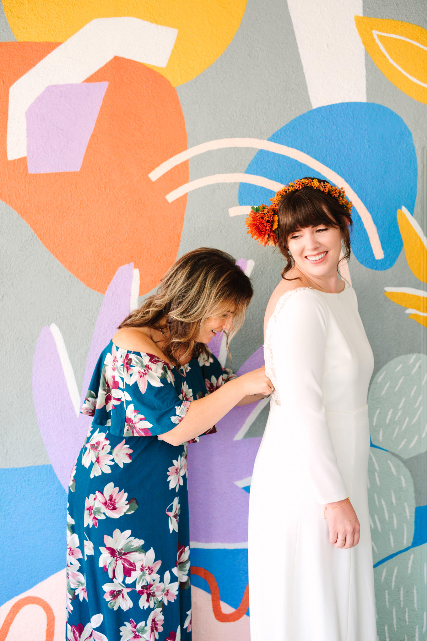 Mother of the bride finishing touches with fun mural | Vibrant backyard micro wedding featured on Green Wedding Shoes | Colorful LA wedding photography | #losangeleswedding #backyardwedding #microwedding #laweddingphotographer Source: Mary Costa Photography | Los Angeles