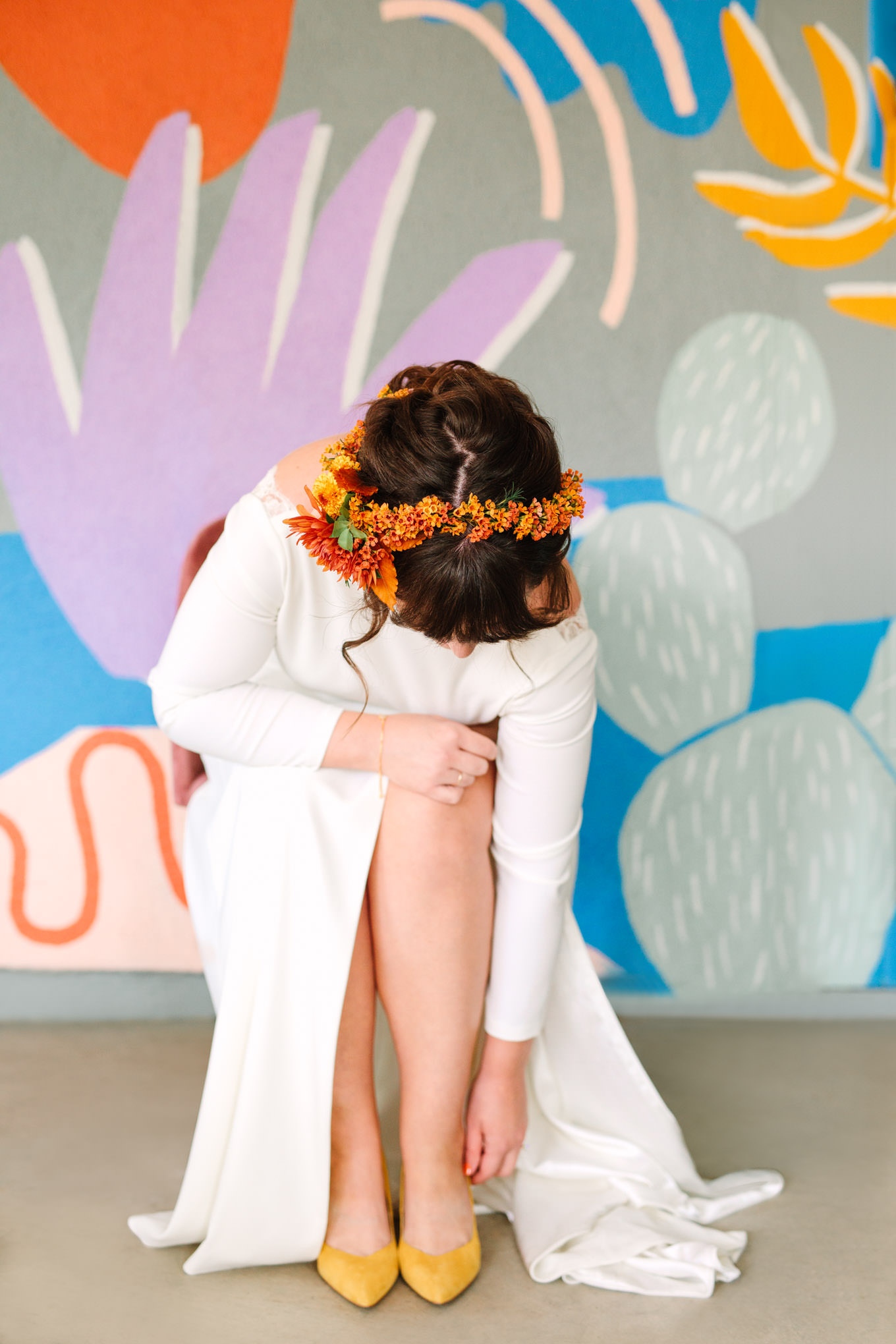 Bride putting on fun. unique wedding shoes | Vibrant backyard micro wedding featured on Green Wedding Shoes | Colorful LA wedding photography | #losangeleswedding #backyardwedding #microwedding #laweddingphotographer Source: Mary Costa Photography | Los Angeles