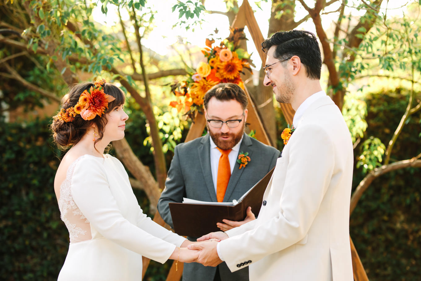 Close up of bride and groom with officiant| Vibrant backyard micro wedding featured on Green Wedding Shoes | Colorful LA wedding photography | #losangeleswedding #backyardwedding #microwedding #laweddingphotographer Source: Mary Costa Photography | Los Angeles