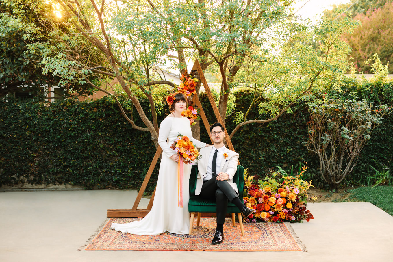 Groom seated with bride standing | Vibrant backyard micro wedding featured on Green Wedding Shoes | Colorful LA wedding photography | #losangeleswedding #backyardwedding #microwedding #laweddingphotographer Source: Mary Costa Photography | Los Angeles