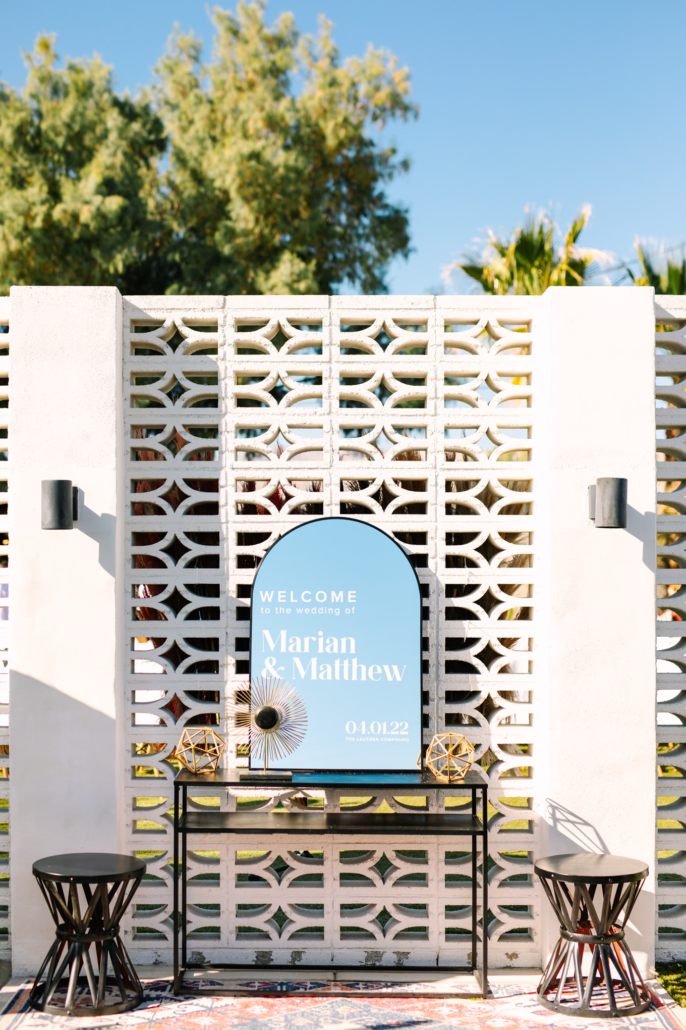 Mirror wedding welcome sign on white breezeblocks | Pink and orange Lautner Compound wedding | Colorful Palm Springs wedding photography | #palmspringsphotographer #palmspringswedding #lautnercompound #southerncaliforniawedding  Source: Mary Costa Photography | Los Angeles