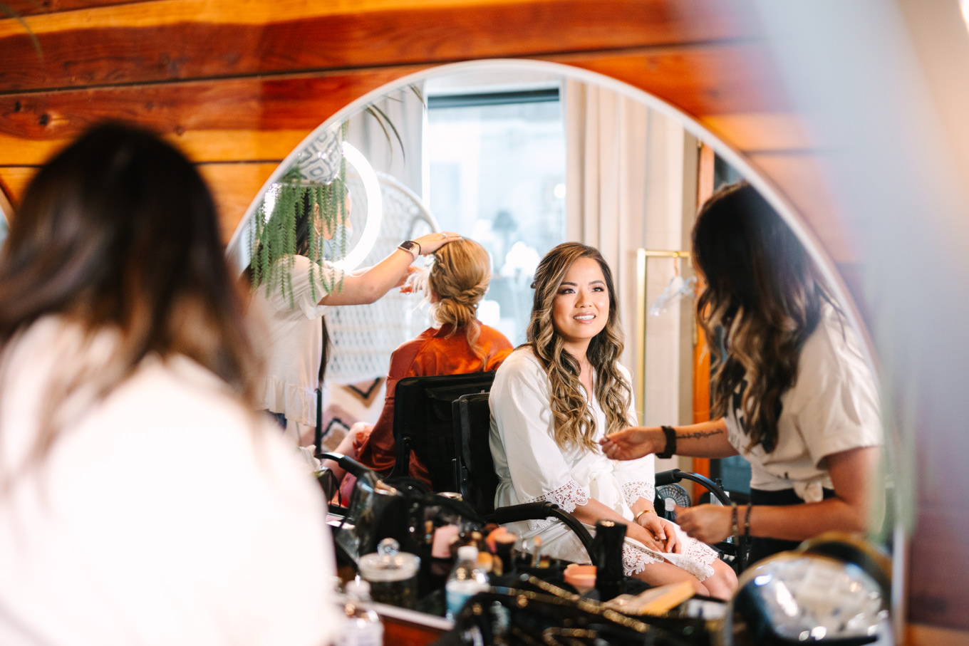 Bride in mirror getting ready | Pink and orange Lautner Compound wedding | Colorful Palm Springs wedding photography | #palmspringsphotographer #palmspringswedding #lautnercompound #southerncaliforniawedding  Source: Mary Costa Photography | Los Angeles