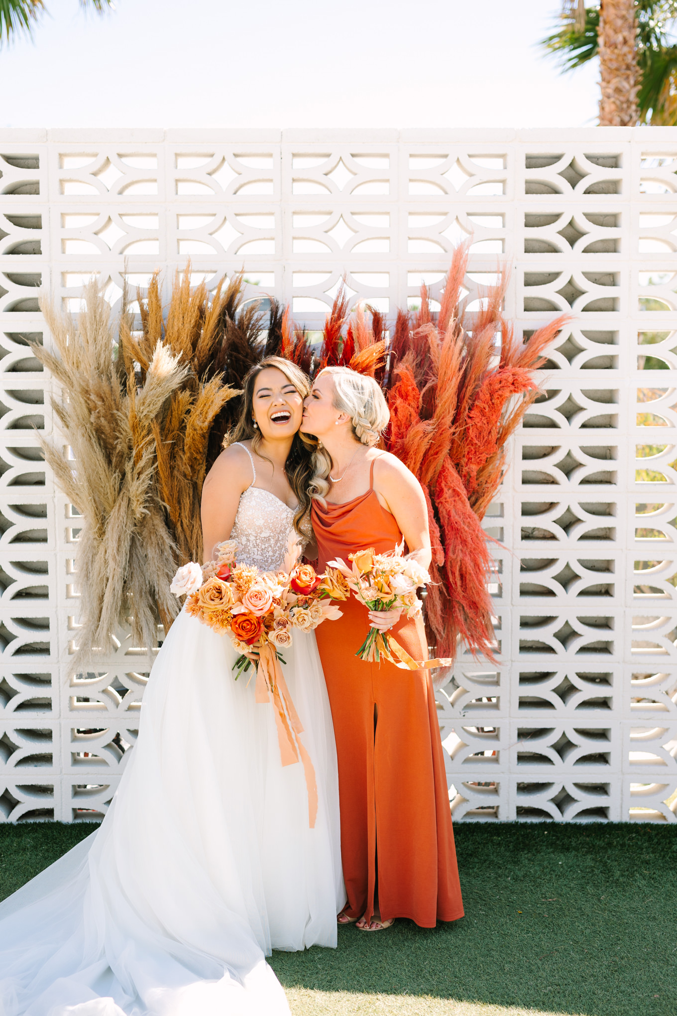 Bride with bridesmaid | Pink and orange Lautner Compound wedding | Colorful Palm Springs wedding photography | #palmspringsphotographer #palmspringswedding #lautnercompound #southerncaliforniawedding  Source: Mary Costa Photography | Los Angeles