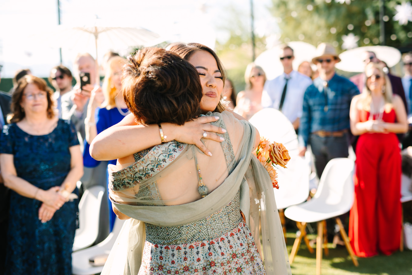 Bride hugging mom at wedding | Pink and orange Lautner Compound wedding | Colorful Palm Springs wedding photography | #palmspringsphotographer #palmspringswedding #lautnercompound #southerncaliforniawedding  Source: Mary Costa Photography | Los Angeles