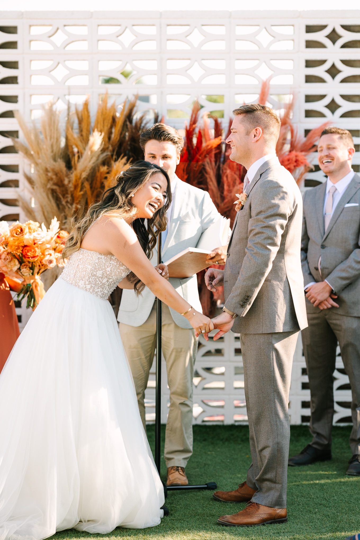 Bride laughing at wedding ceremony | Pink and orange Lautner Compound wedding | Colorful Palm Springs wedding photography | #palmspringsphotographer #palmspringswedding #lautnercompound #southerncaliforniawedding  Source: Mary Costa Photography | Los Angeles