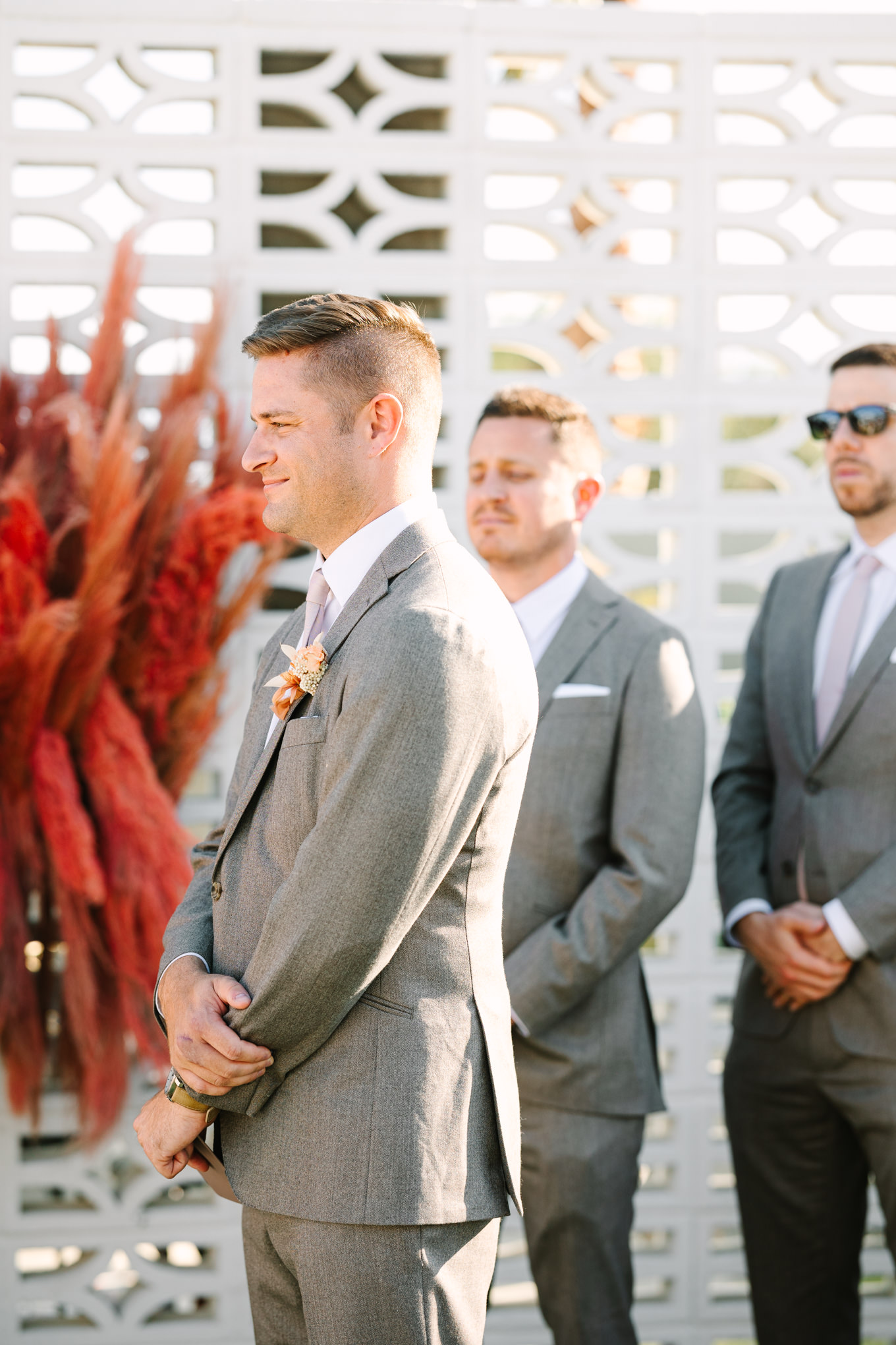 Groom listening to bride's vows | Pink and orange Lautner Compound wedding | Colorful Palm Springs wedding photography | #palmspringsphotographer #palmspringswedding #lautnercompound #southerncaliforniawedding  Source: Mary Costa Photography | Los Angeles