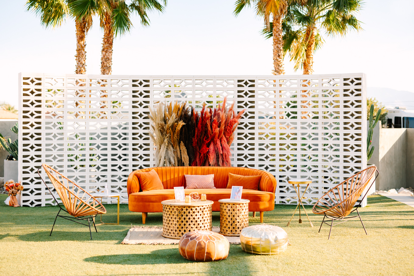 Lounge setup with orange velvet couch | Pink and orange Lautner Compound wedding | Colorful Palm Springs wedding photography | #palmspringsphotographer #palmspringswedding #lautnercompound #southerncaliforniawedding  Source: Mary Costa Photography | Los Angeles