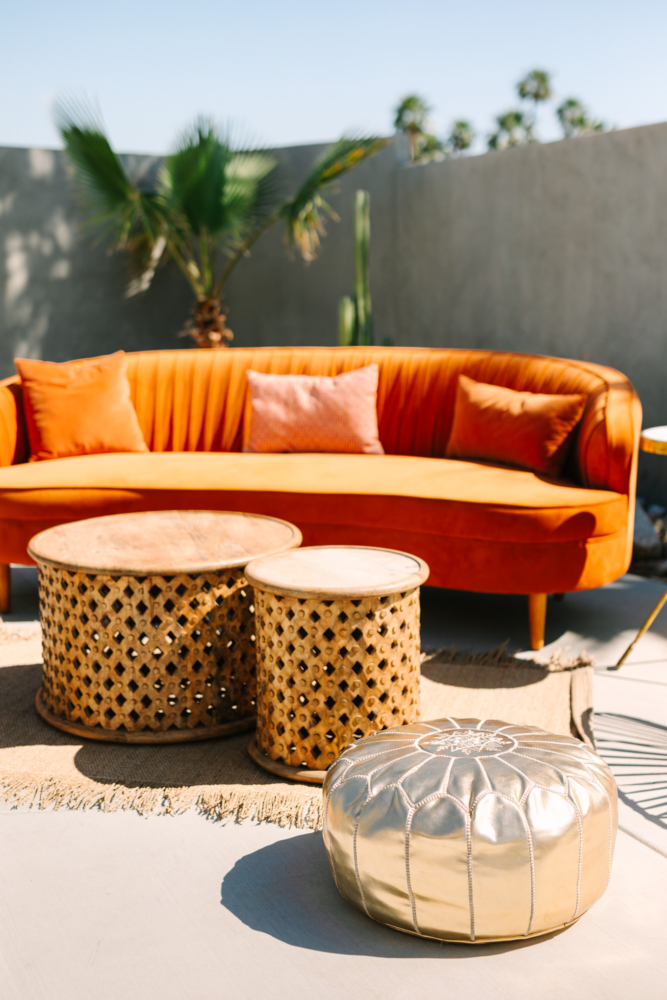 Gold boho pouf with velvet couch | Pink and orange Lautner Compound wedding | Colorful Palm Springs wedding photography | #palmspringsphotographer #palmspringswedding #lautnercompound #southerncaliforniawedding  Source: Mary Costa Photography | Los Angeles
