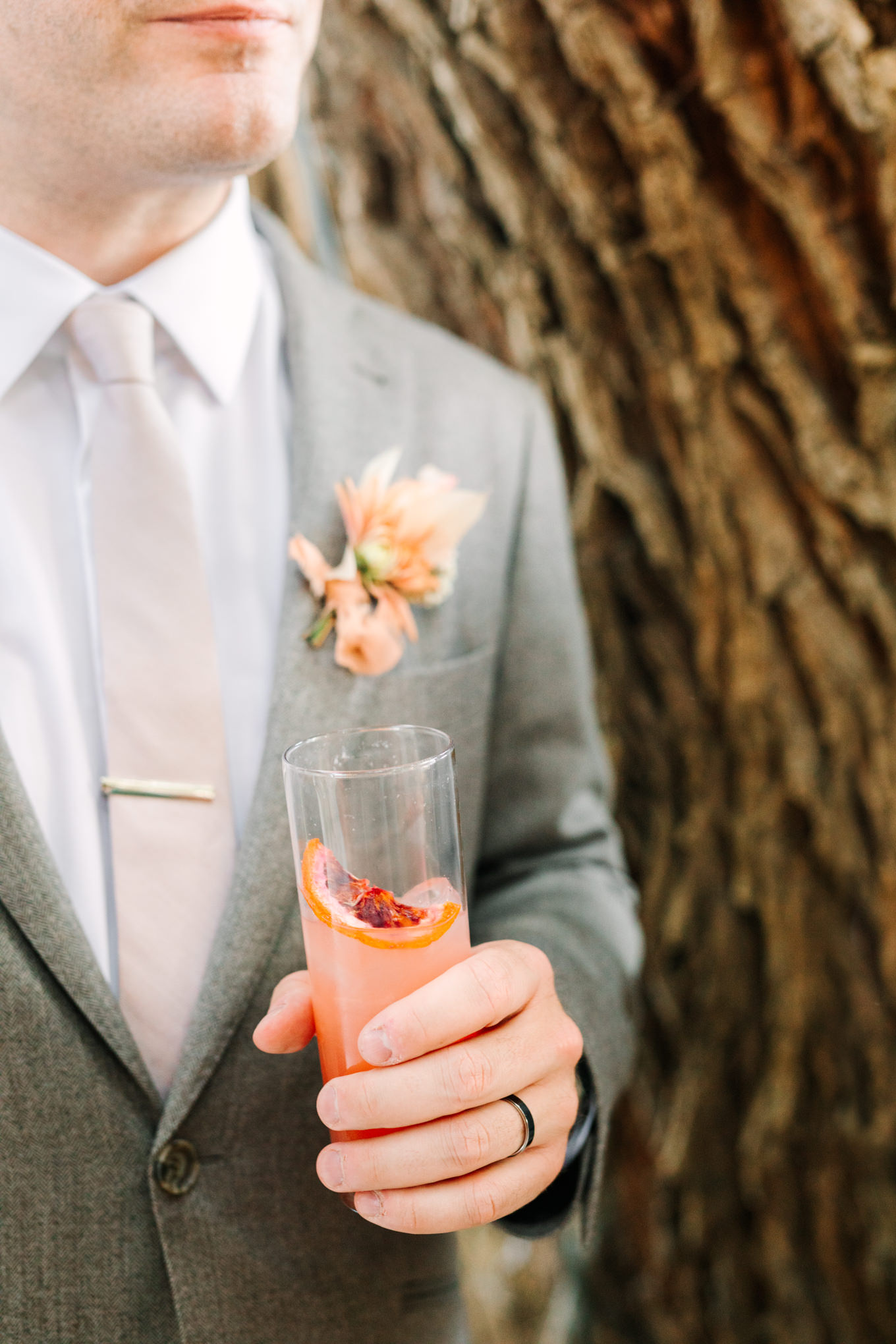 Groom holding cocktail | Pink and orange Lautner Compound wedding | Colorful Palm Springs wedding photography | #palmspringsphotographer #palmspringswedding #lautnercompound #southerncaliforniawedding  Source: Mary Costa Photography | Los Angeles