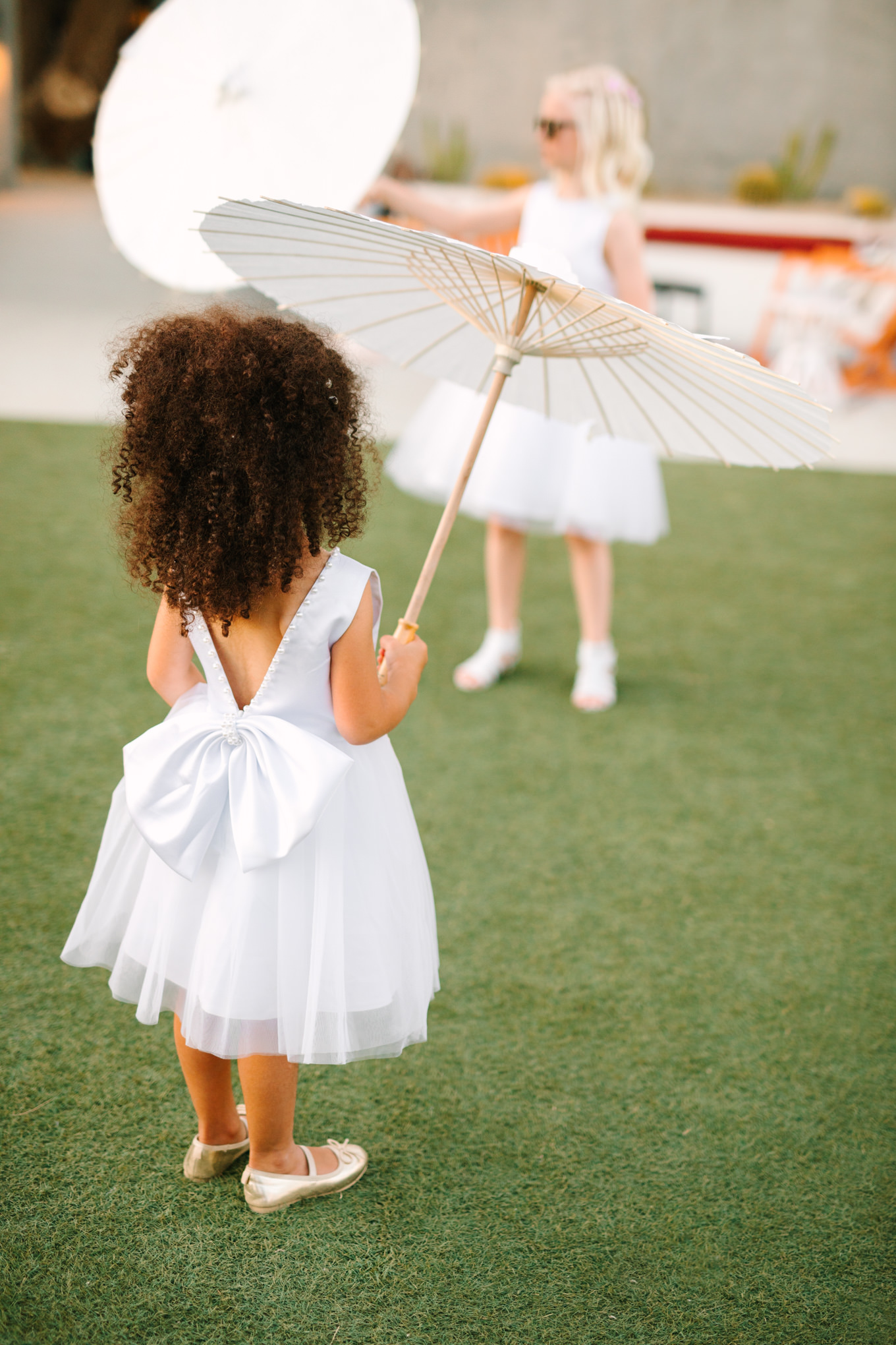 Flower girl dress bow | Pink and orange Lautner Compound wedding | Colorful Palm Springs wedding photography | #palmspringsphotographer #palmspringswedding #lautnercompound #southerncaliforniawedding  Source: Mary Costa Photography | Los Angeles
