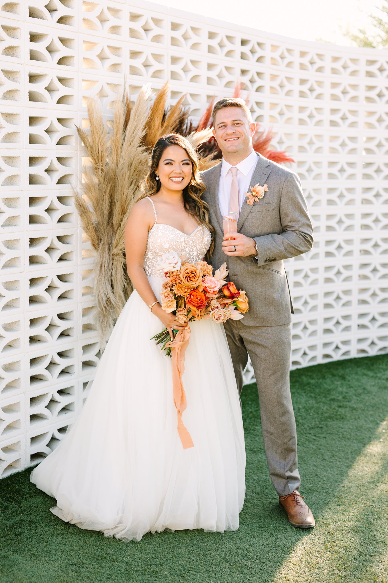 Bride and groom on white breeze block wall | Pink and orange Lautner Compound wedding | Colorful Palm Springs wedding photography | #palmspringsphotographer #palmspringswedding #lautnercompound #southerncaliforniawedding  Source: Mary Costa Photography | Los Angeles