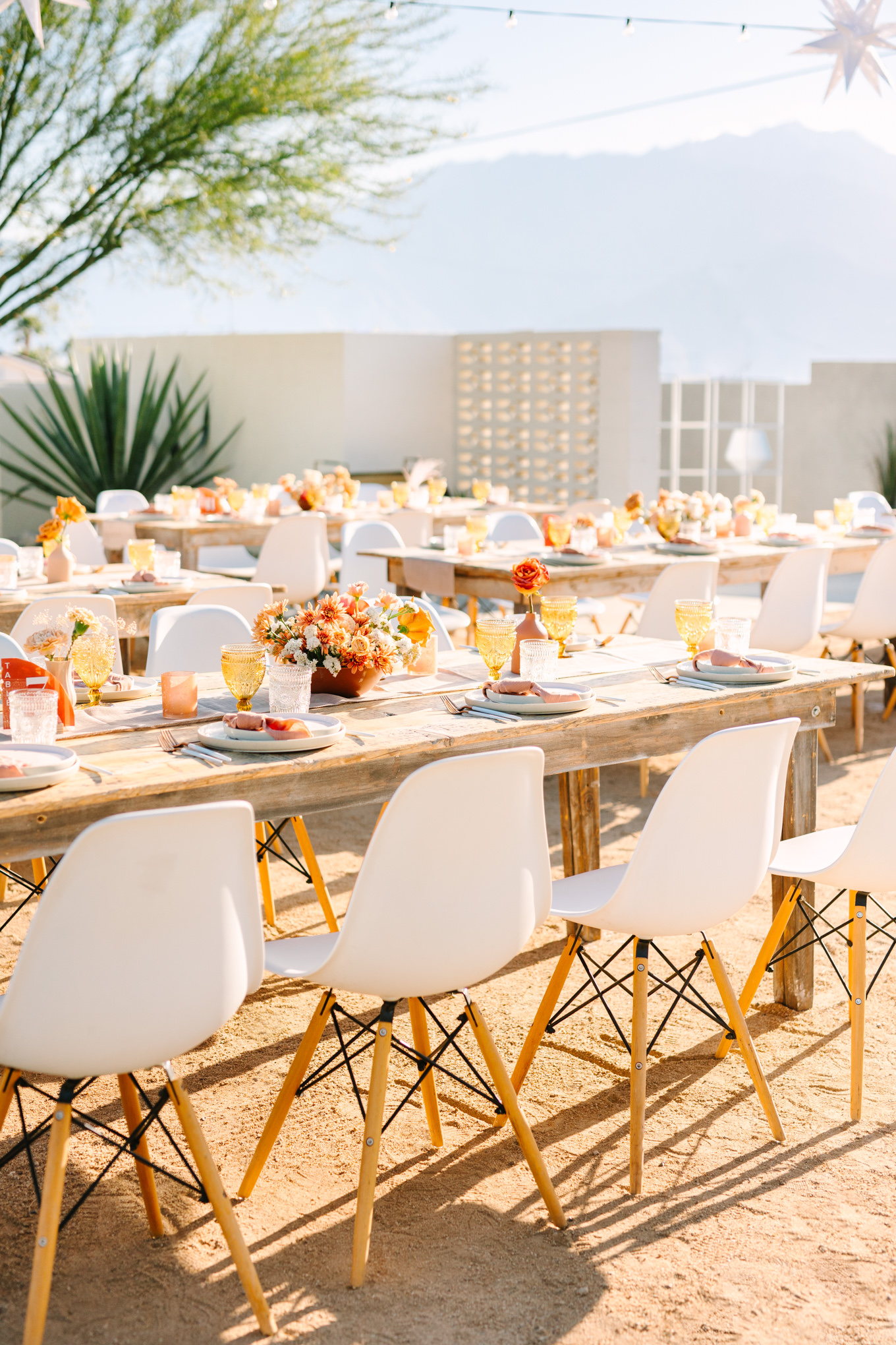 White bucket chairs at wedding reception | Pink and orange Lautner Compound wedding | Colorful Palm Springs wedding photography | #palmspringsphotographer #palmspringswedding #lautnercompound #southerncaliforniawedding  Source: Mary Costa Photography | Los Angeles